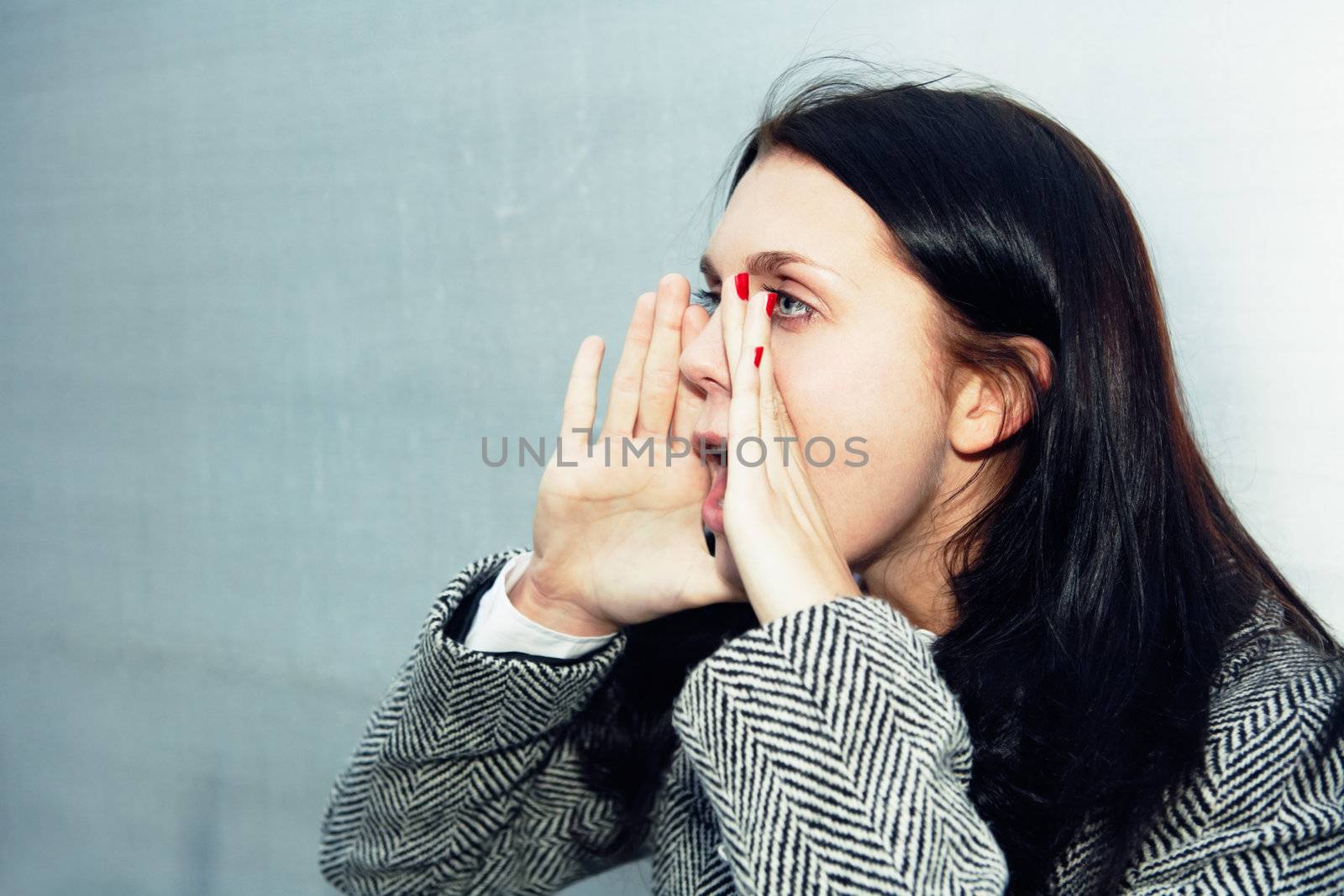 Young woman shouting beside building wall