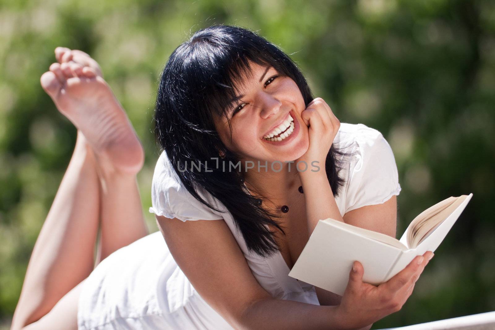 female laughing in a park with a book by vilevi