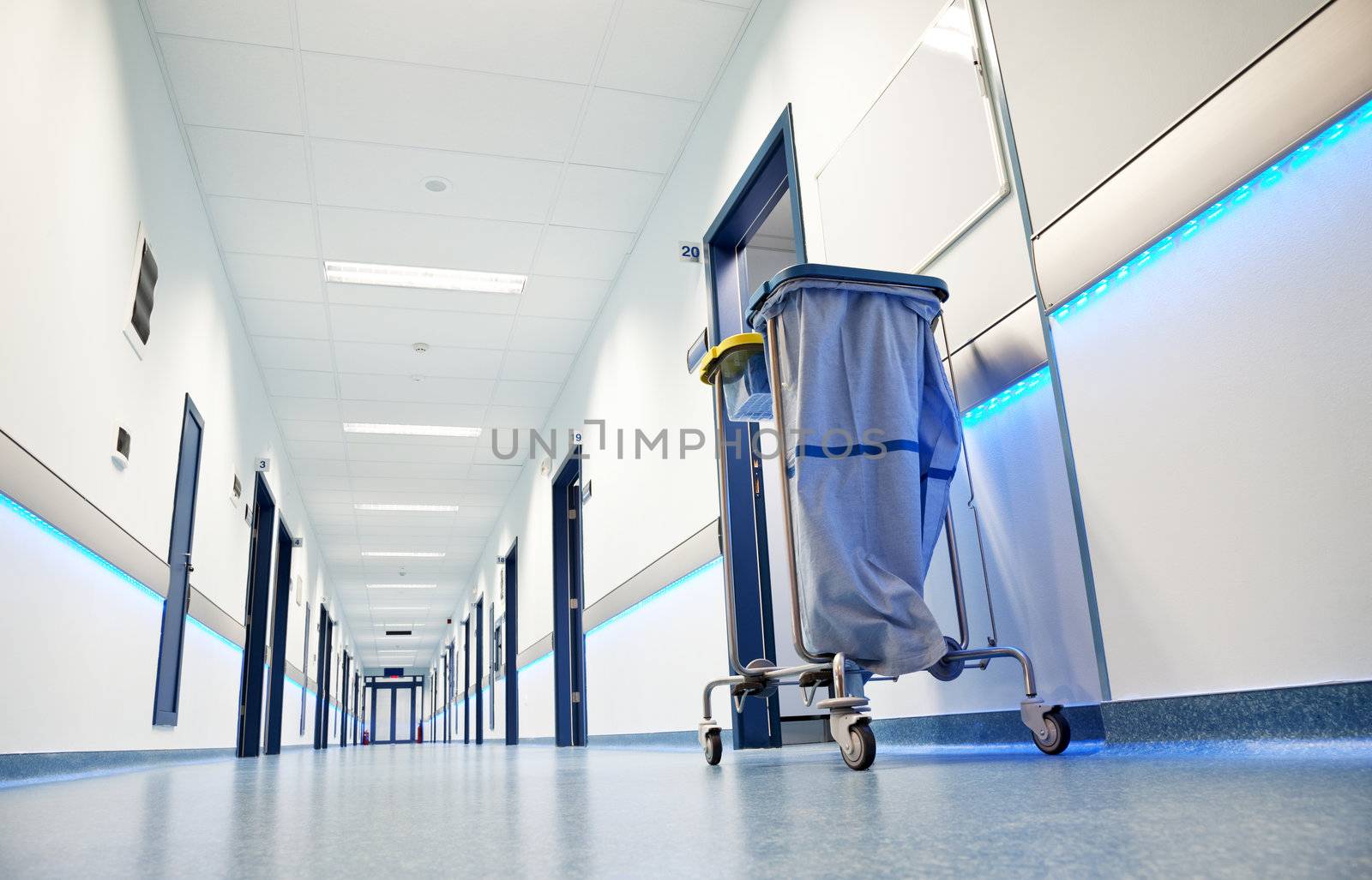 clean white long hospital corridor with blue leading lights