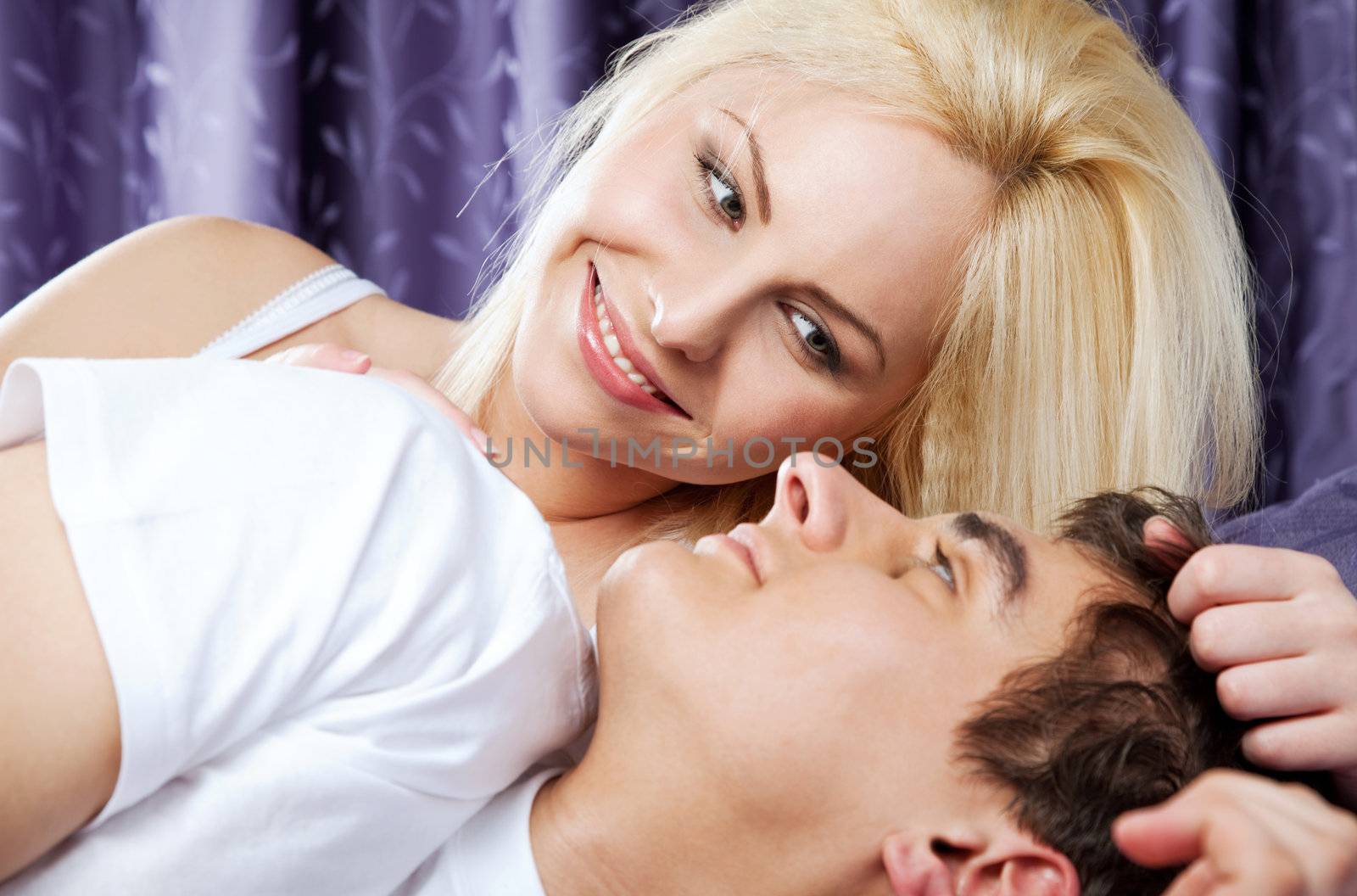 happy young couple in bed awaken by the sun