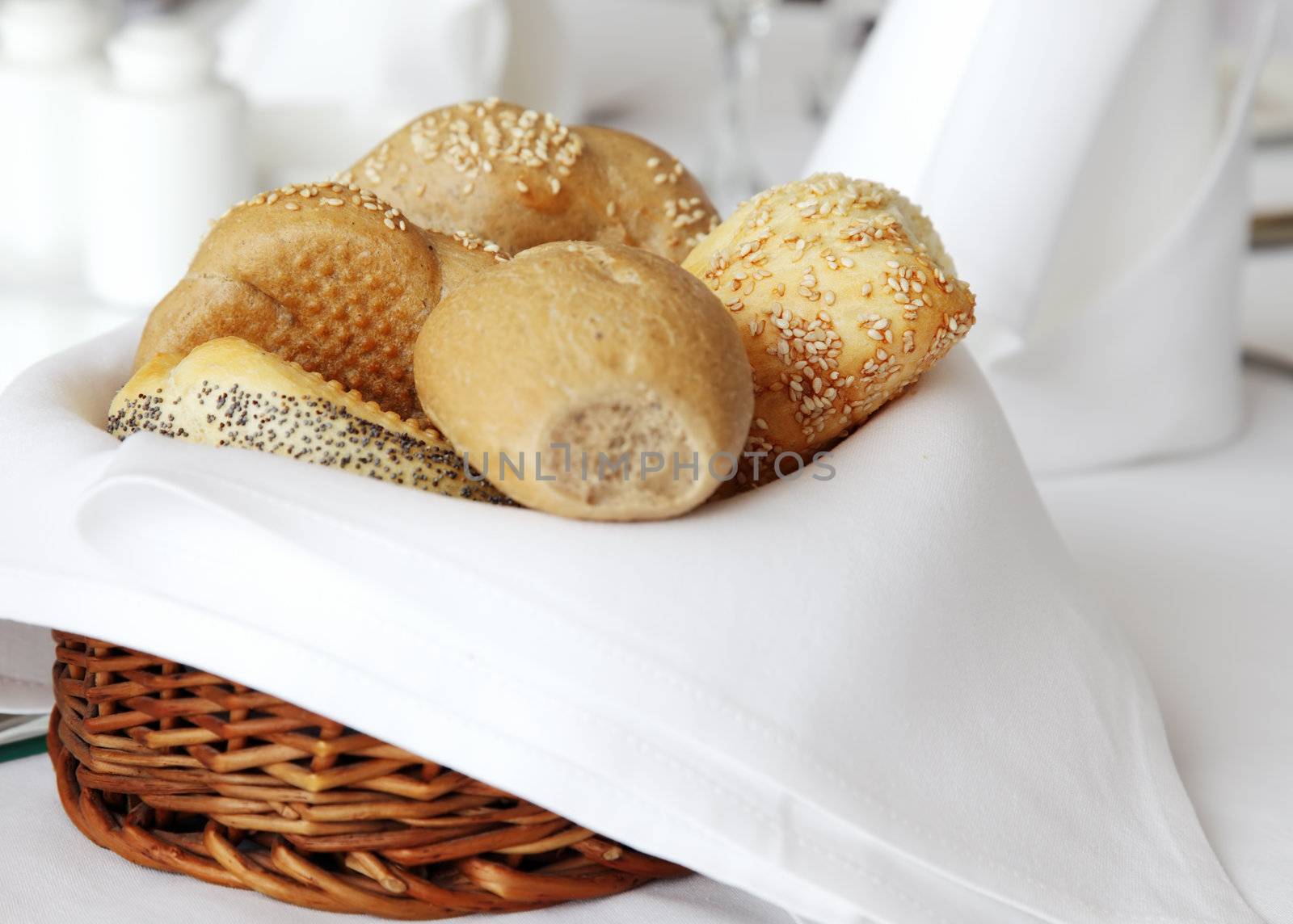 wooden basket covered with white cloth full of small bread