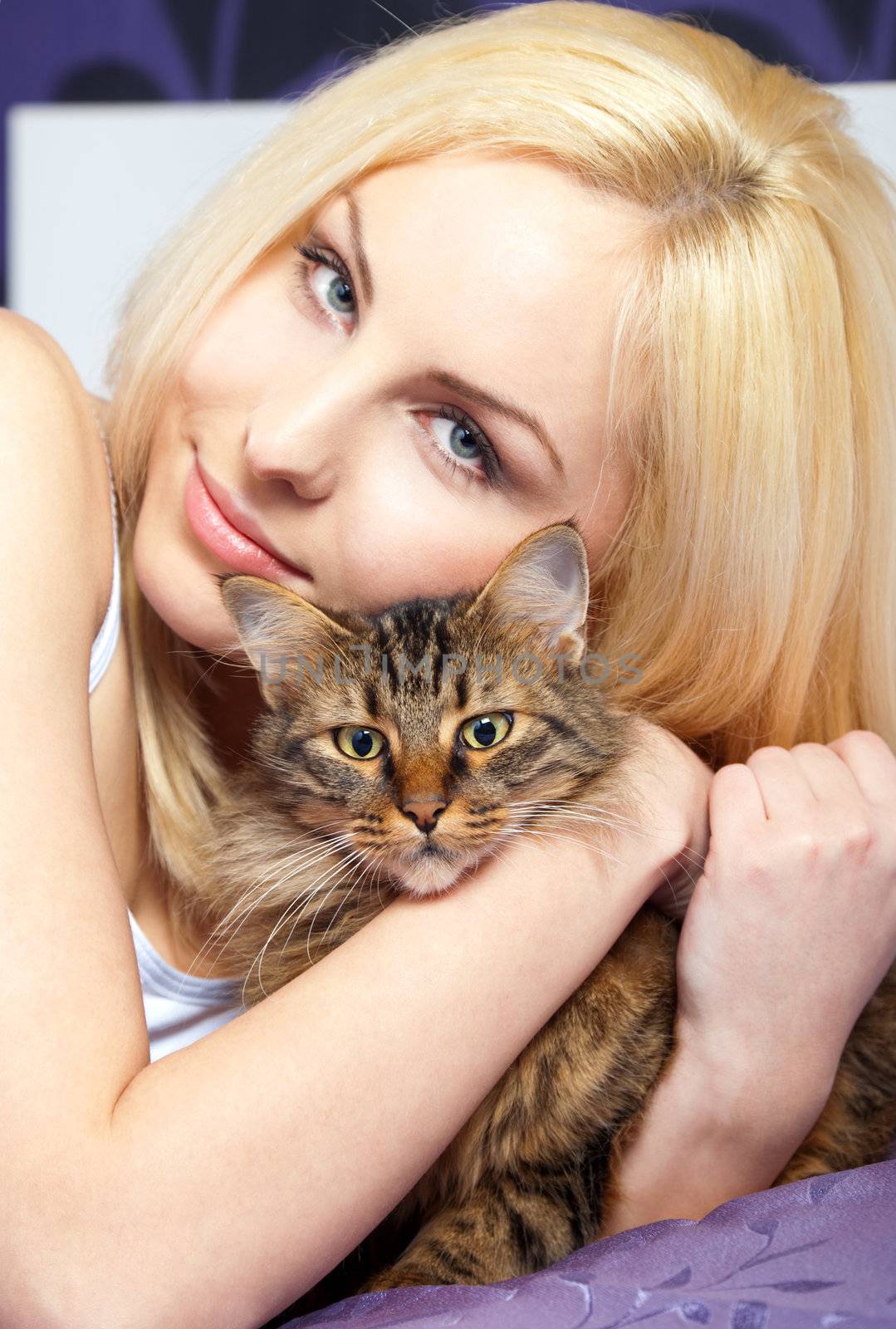 Portrait of a beautiful young woman cuddling a cat