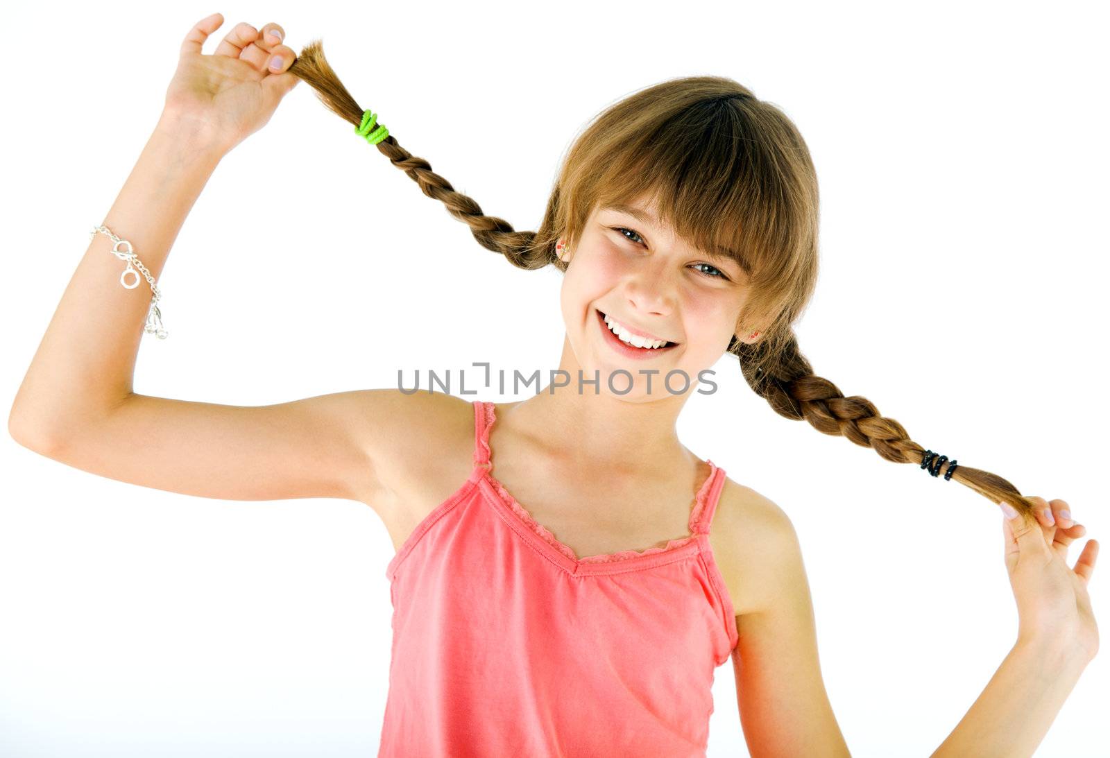 Portrait of happy little girl holding her braids, smiling at camera, isolated on white