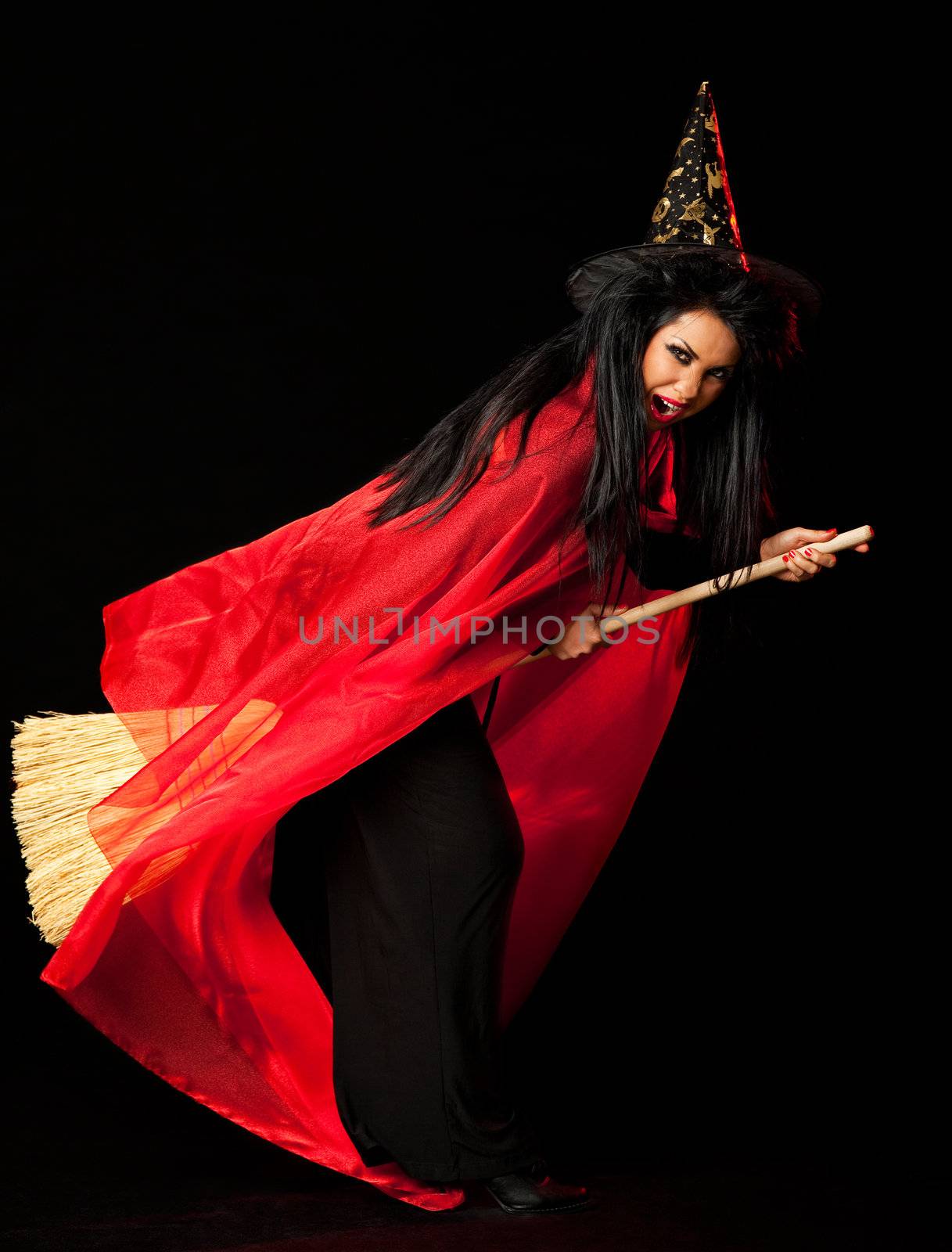 witch with a red cloak, hat and a broom between her legs