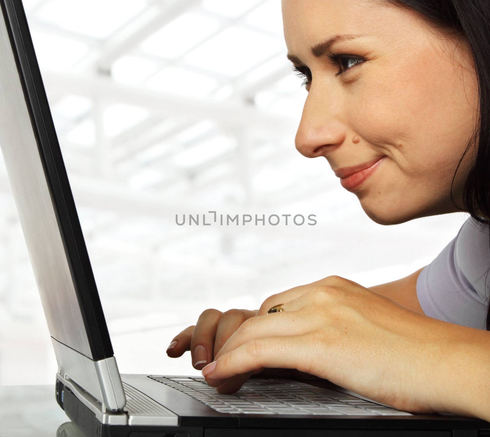 close-up of a female working profoundly on a laptop, smiling