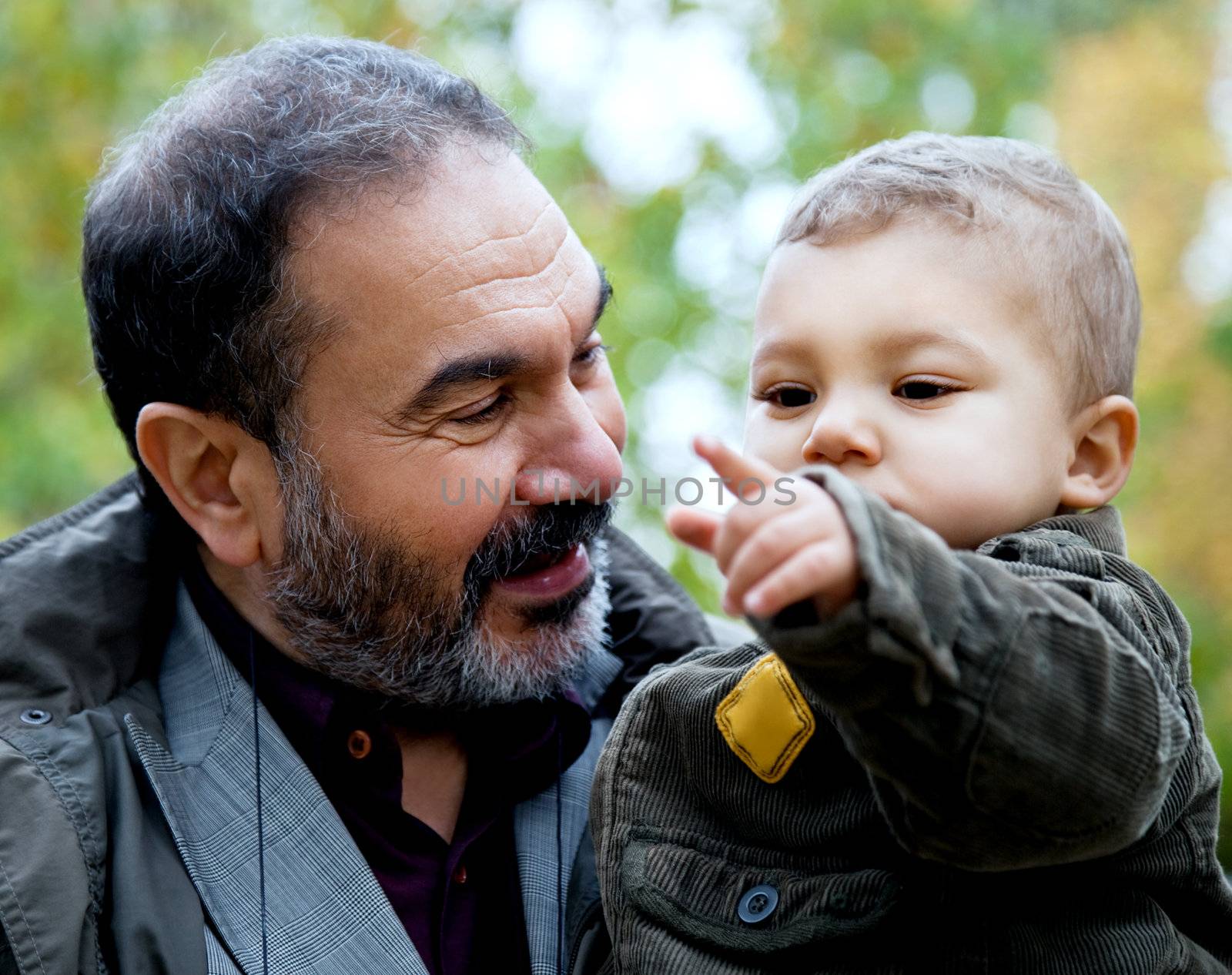 Close-up child being held by grandfather pointing forward