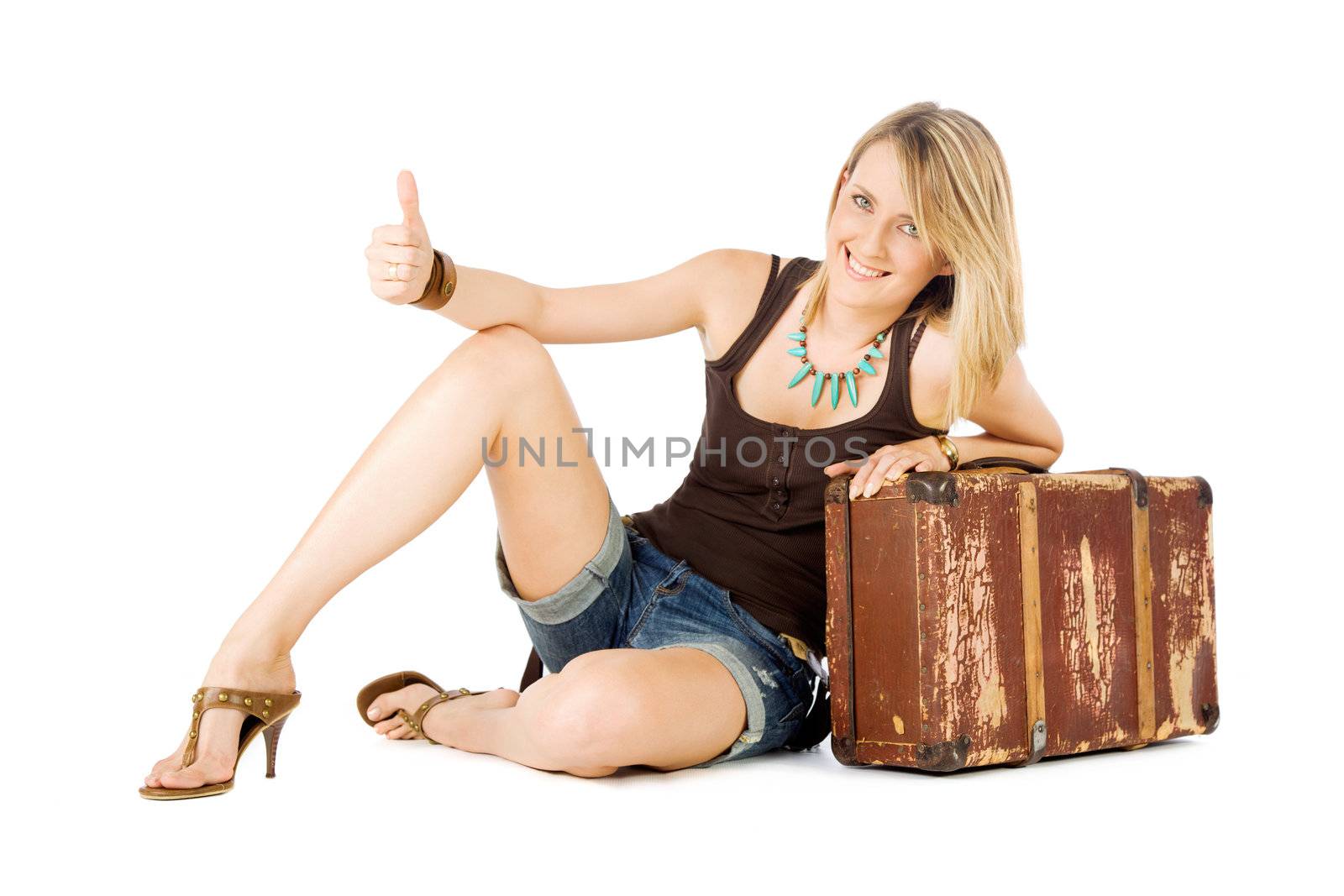 Happy casual woman leaning on an old suitcase hitchhiking, isolated on white