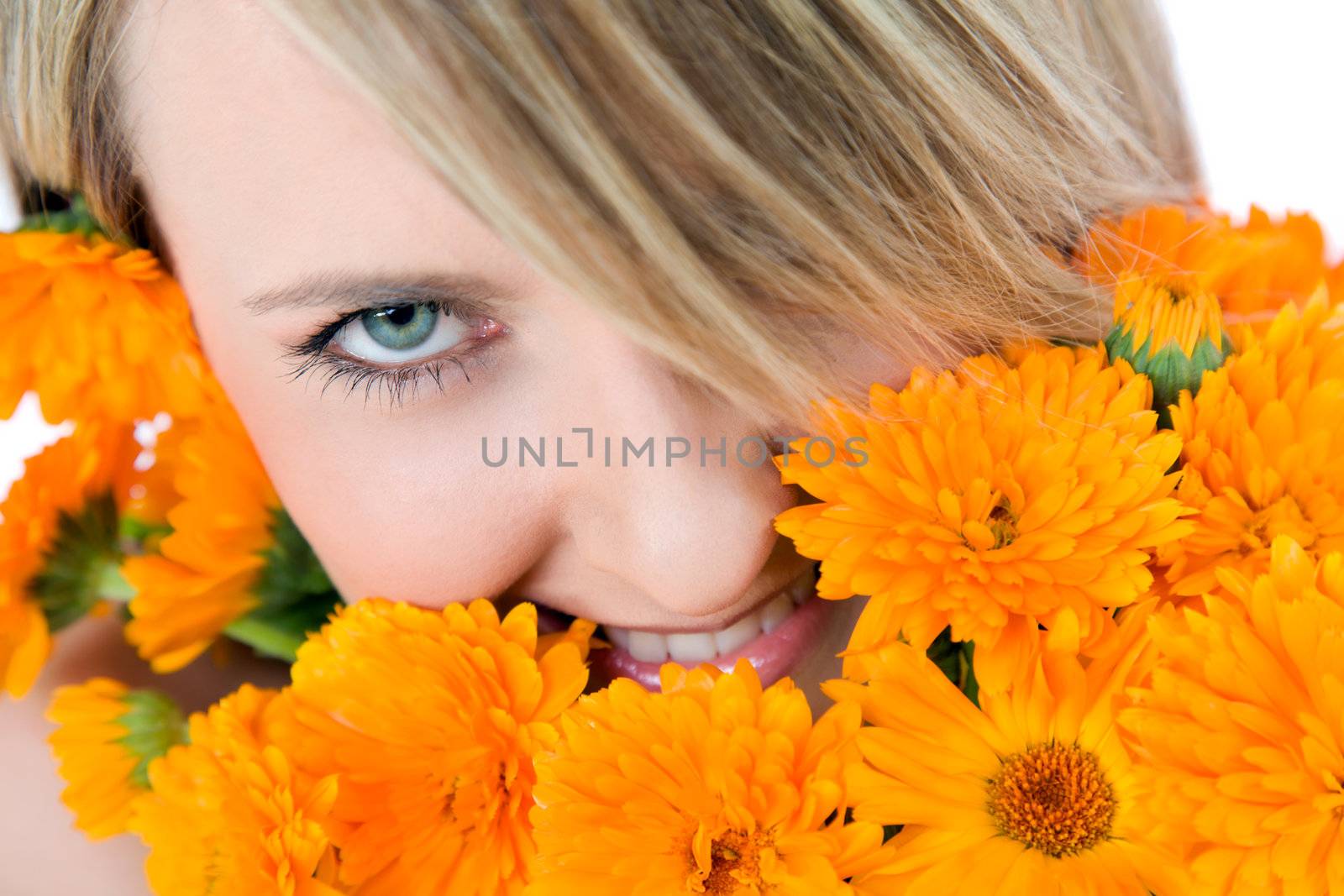 Close-up of beautiful female face holding marigolds, colourfull eye looking at camera