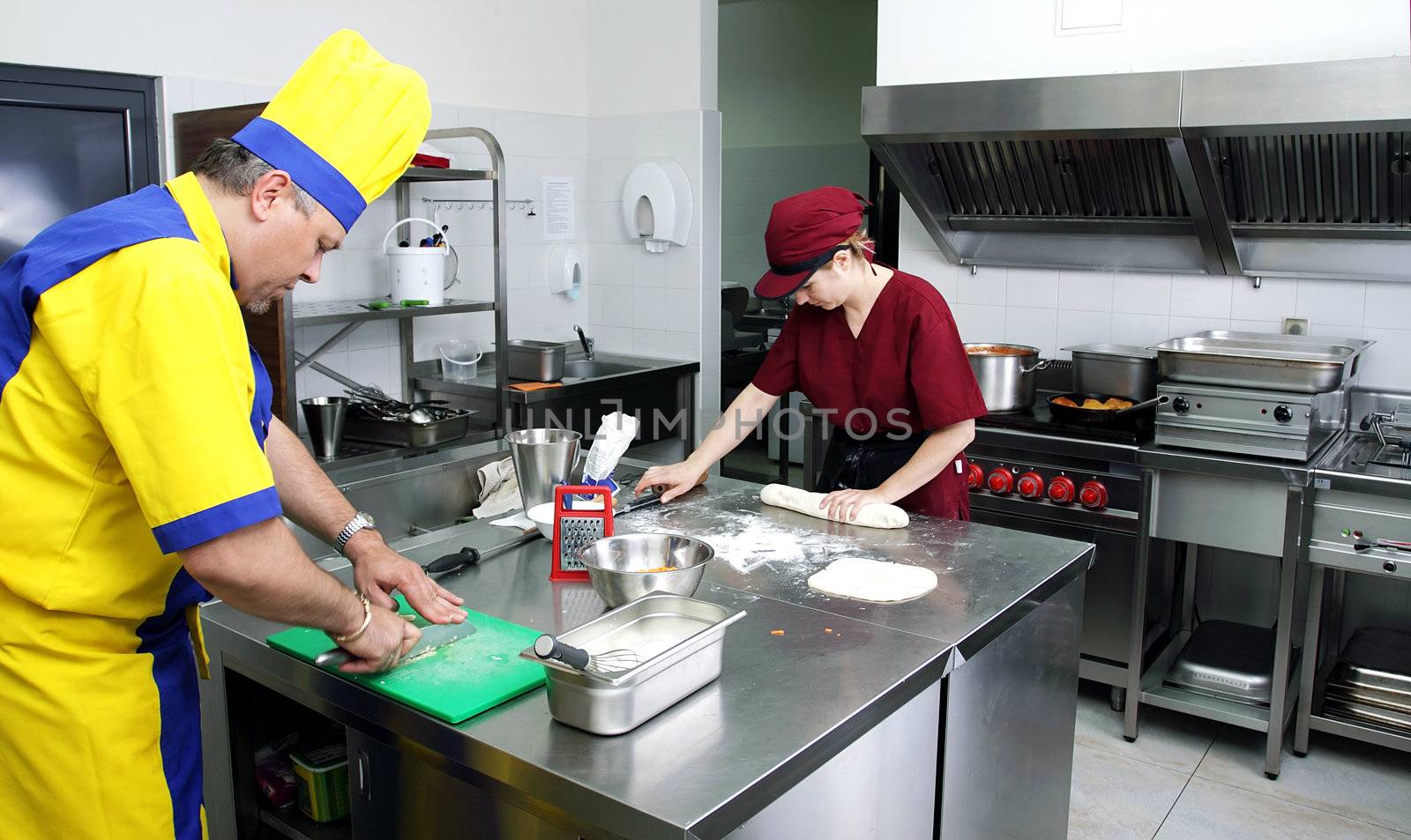 couple of cooks in action in a restaurant kitchen