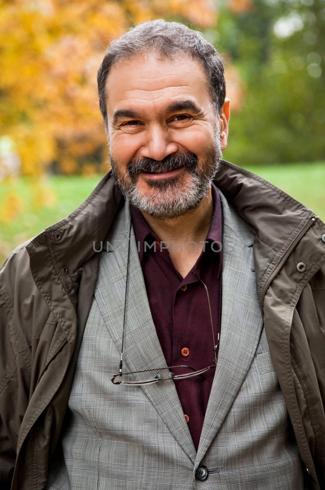 Portrait of happy adult man smiling in autumn park