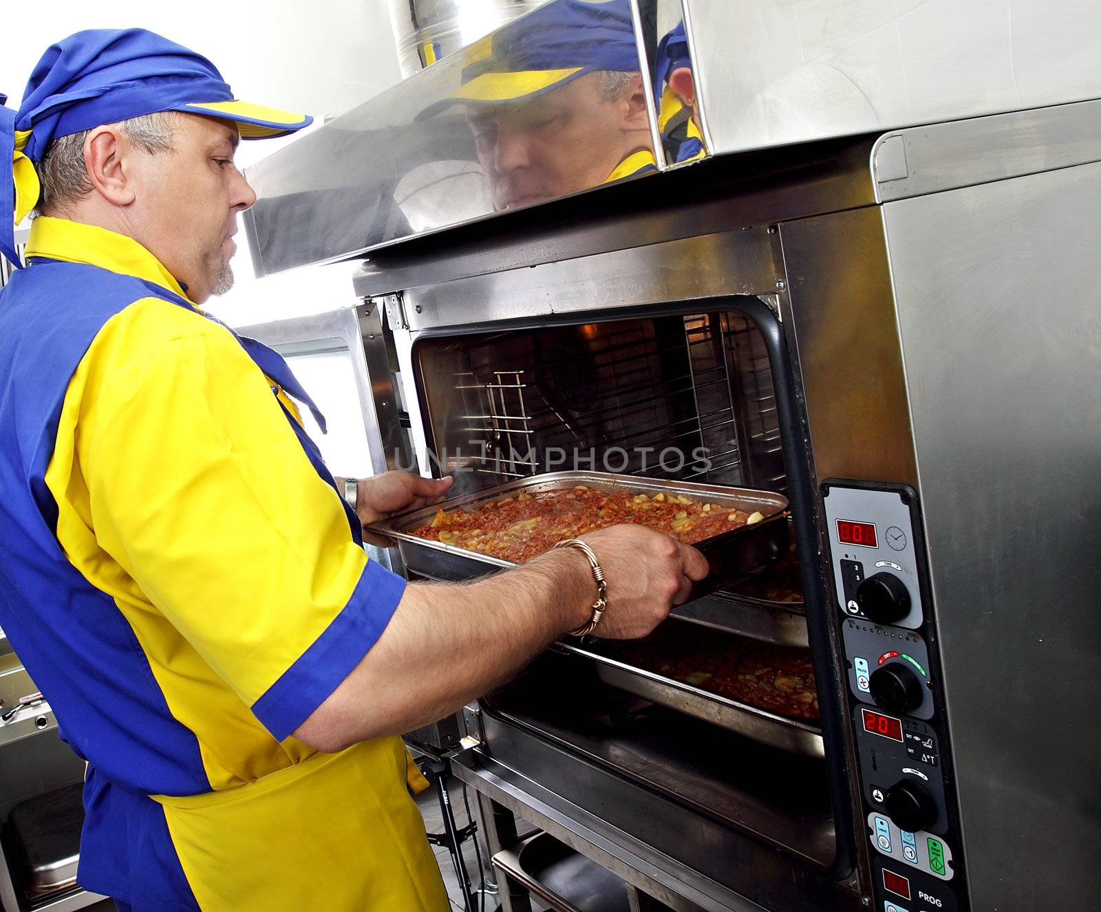 a cook inserts a dish in the oven