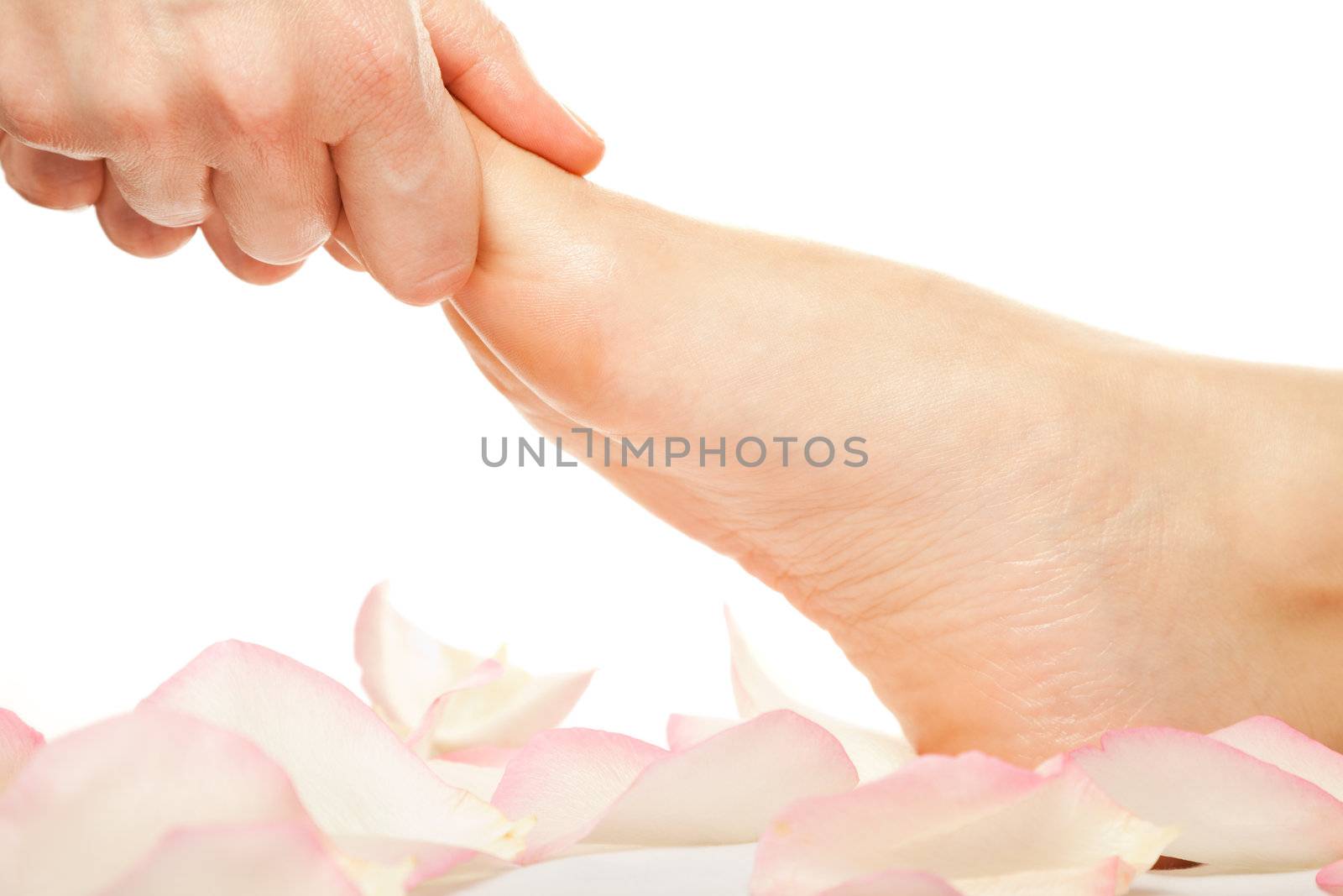 Close-up of hands giving a foot massage isolated on white