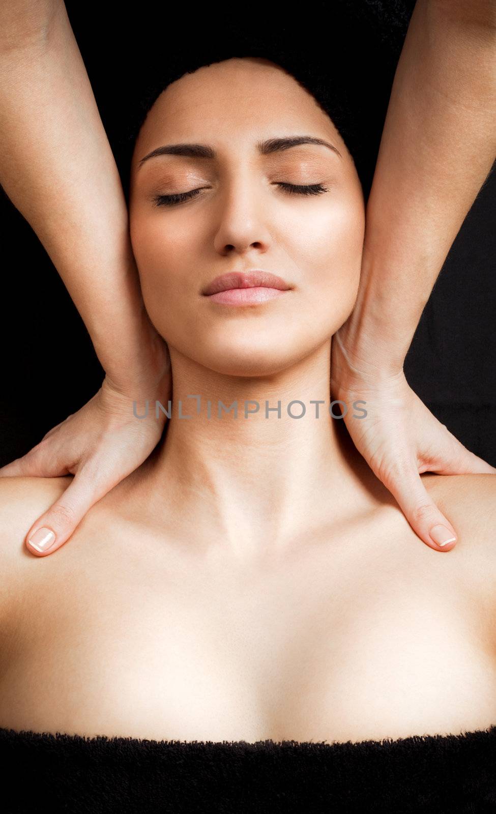 Beautiful young female receiving shoulder massage in spa, relaxed