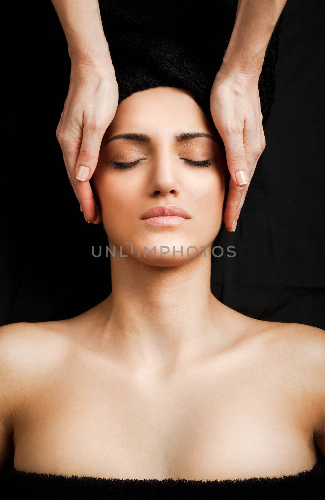 beautiful young female receiving gentle facial massage, eyes closed
