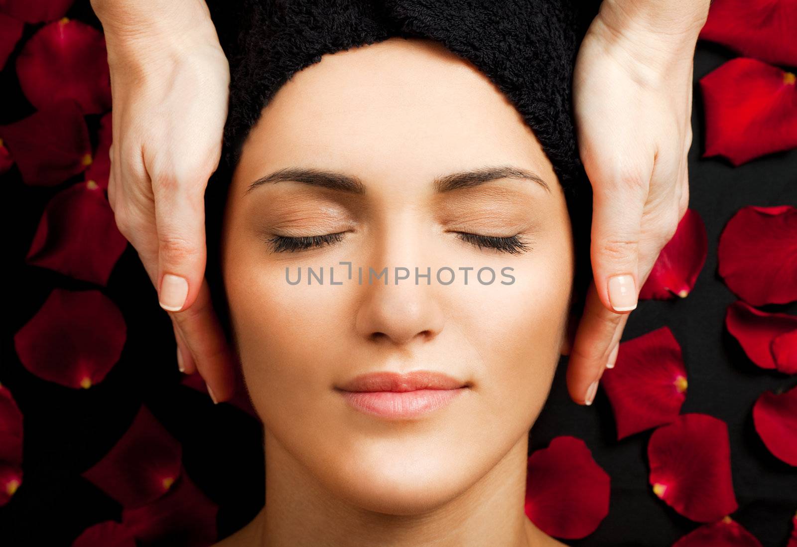 Beautiful young woman receiving face massage at spa