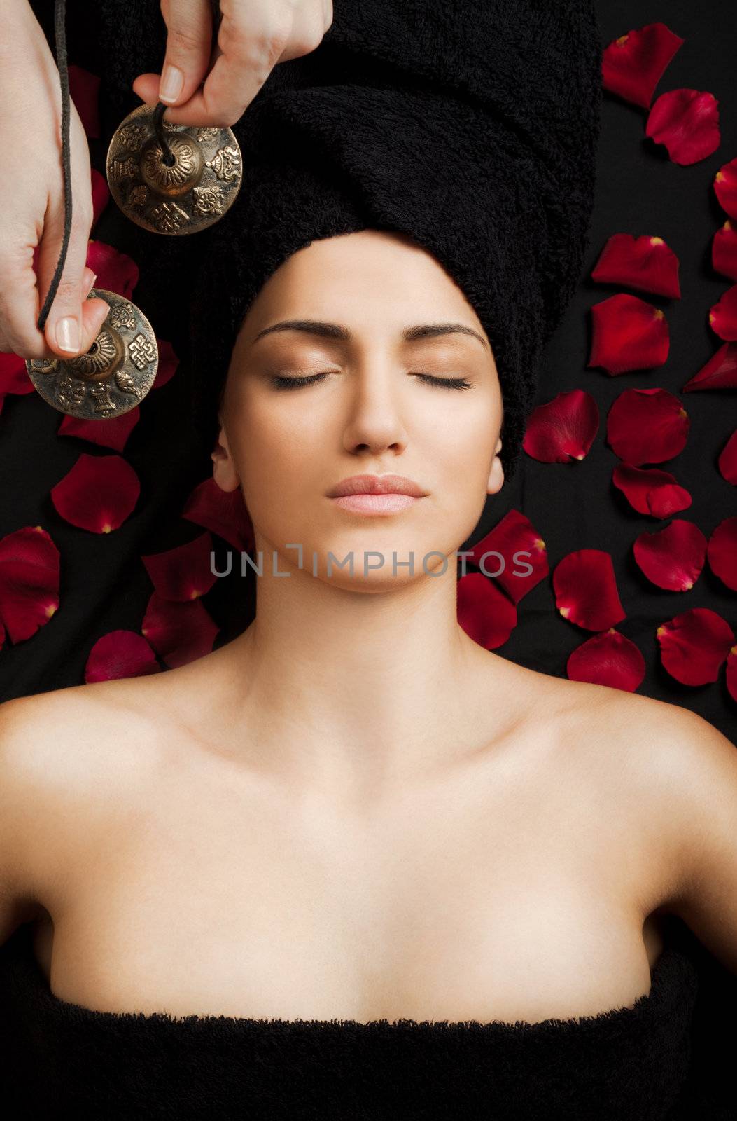 Beautiful female receiving energy sound massage in spa, eyes closed