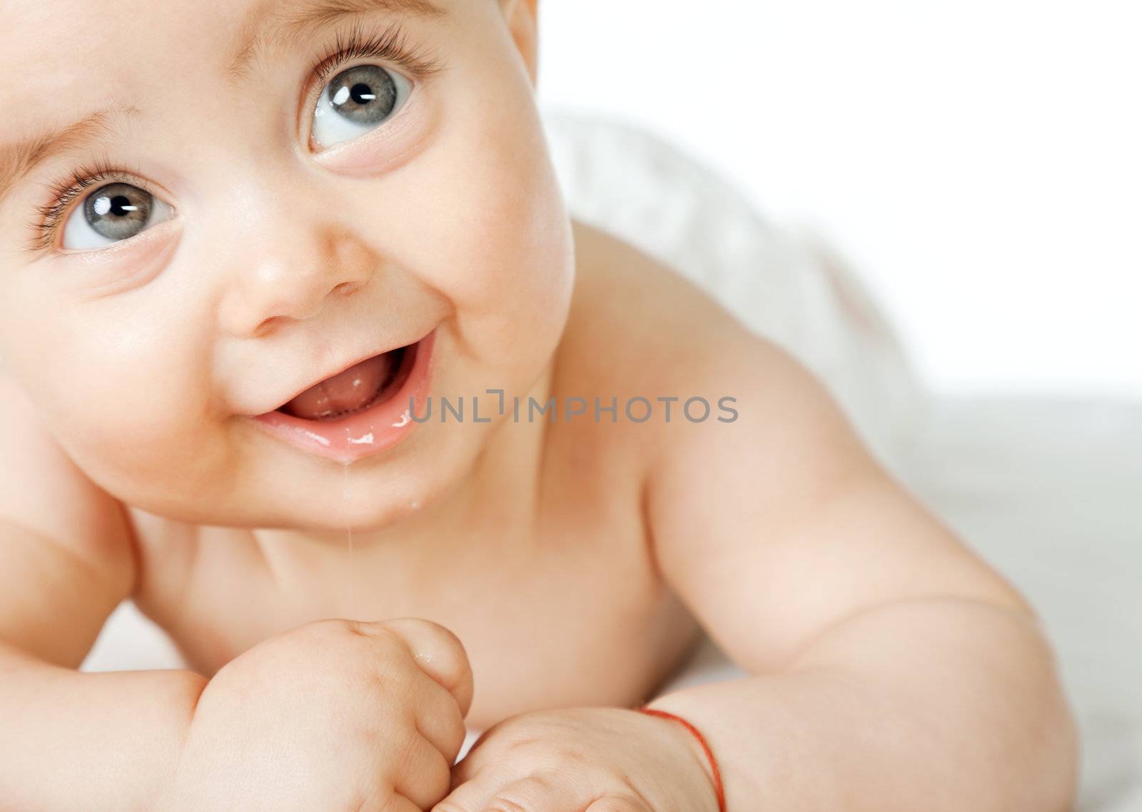 Close-up of sweet little baby face, smiling and looking up, copyspace