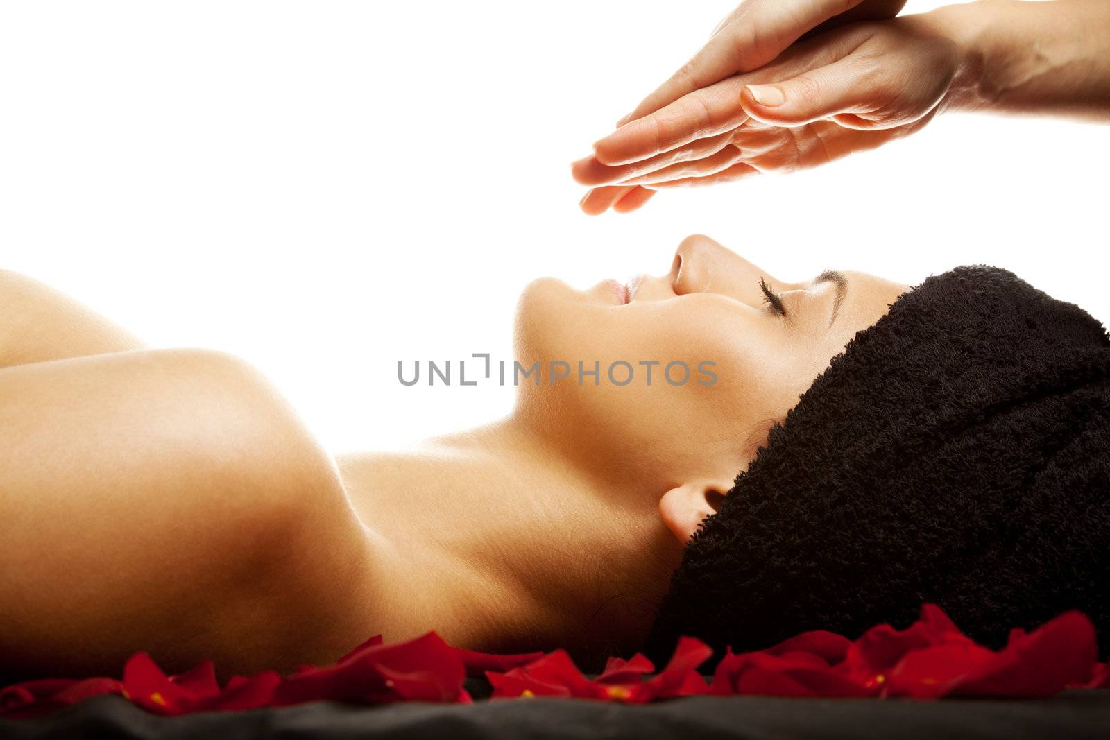 Young woman having a facial energy massage, isolated on white