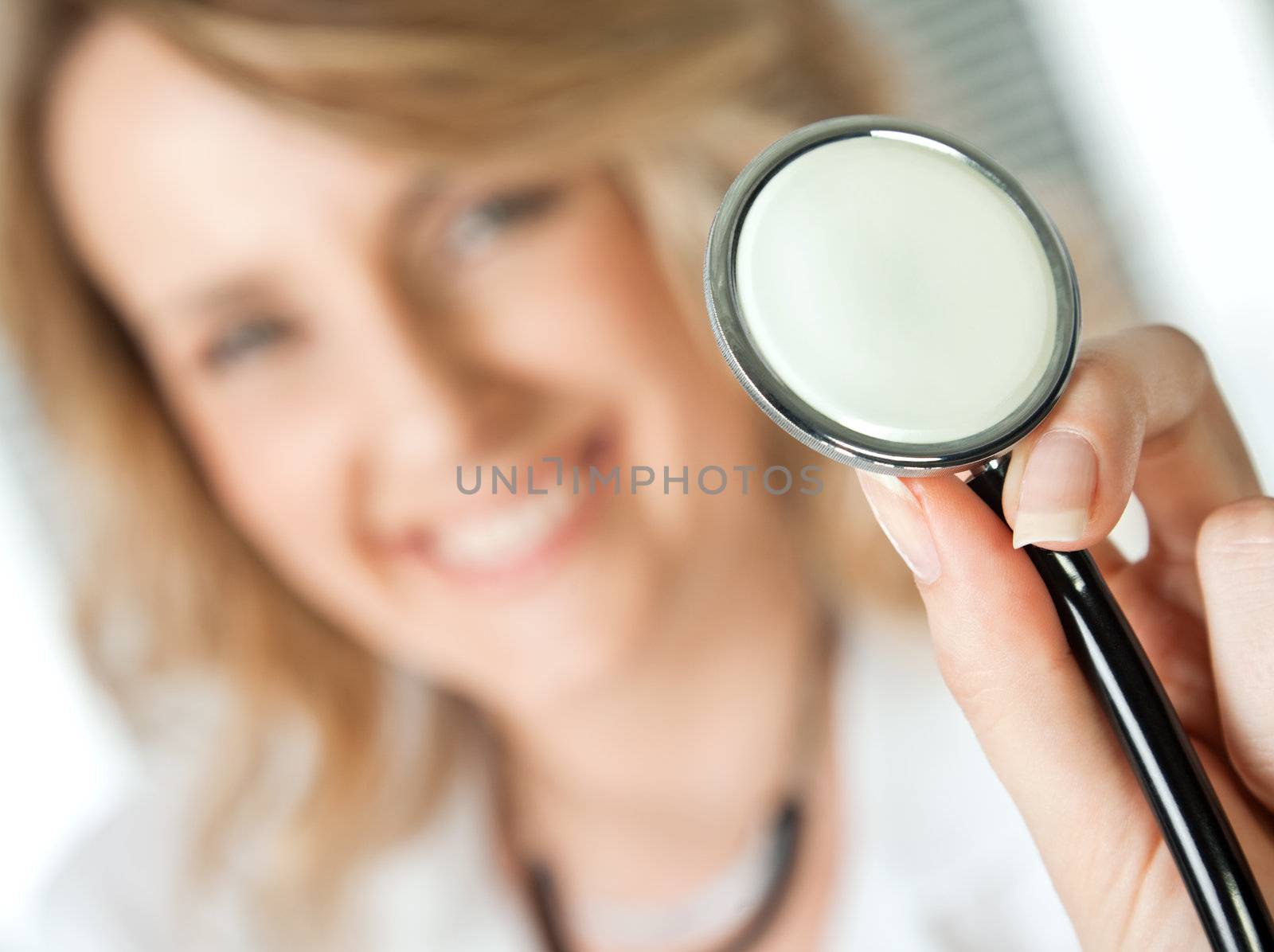Close-up of stethoscope, being held by female blonde doctor, focus on instrument