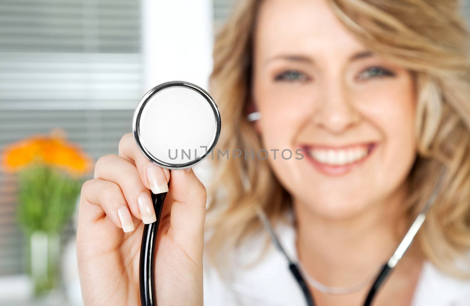 Close-up of stethoscope, being held by smiling female doctor, focus on instrument