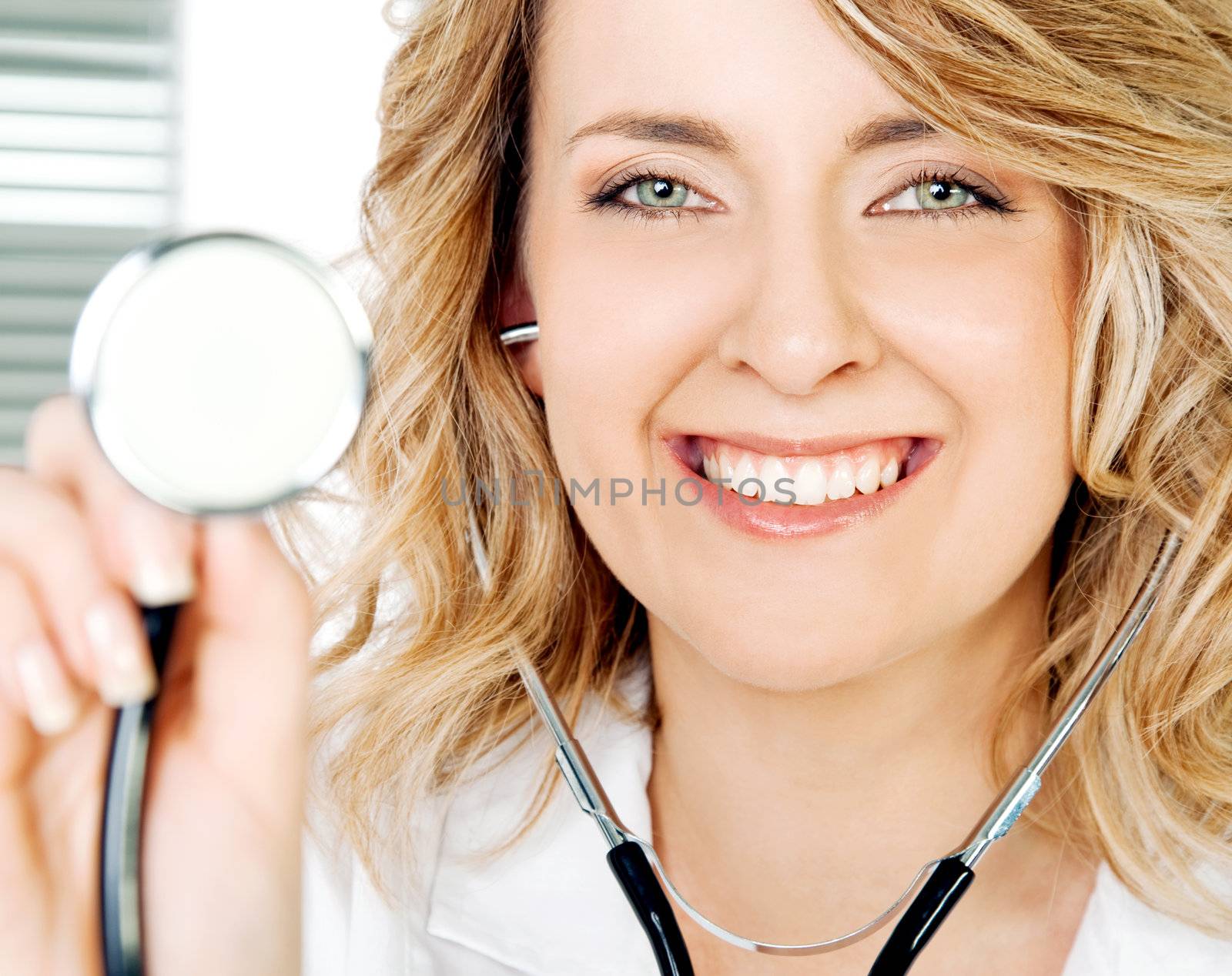 Close-up of smiling female doctor holding stethoscope, looking at camera