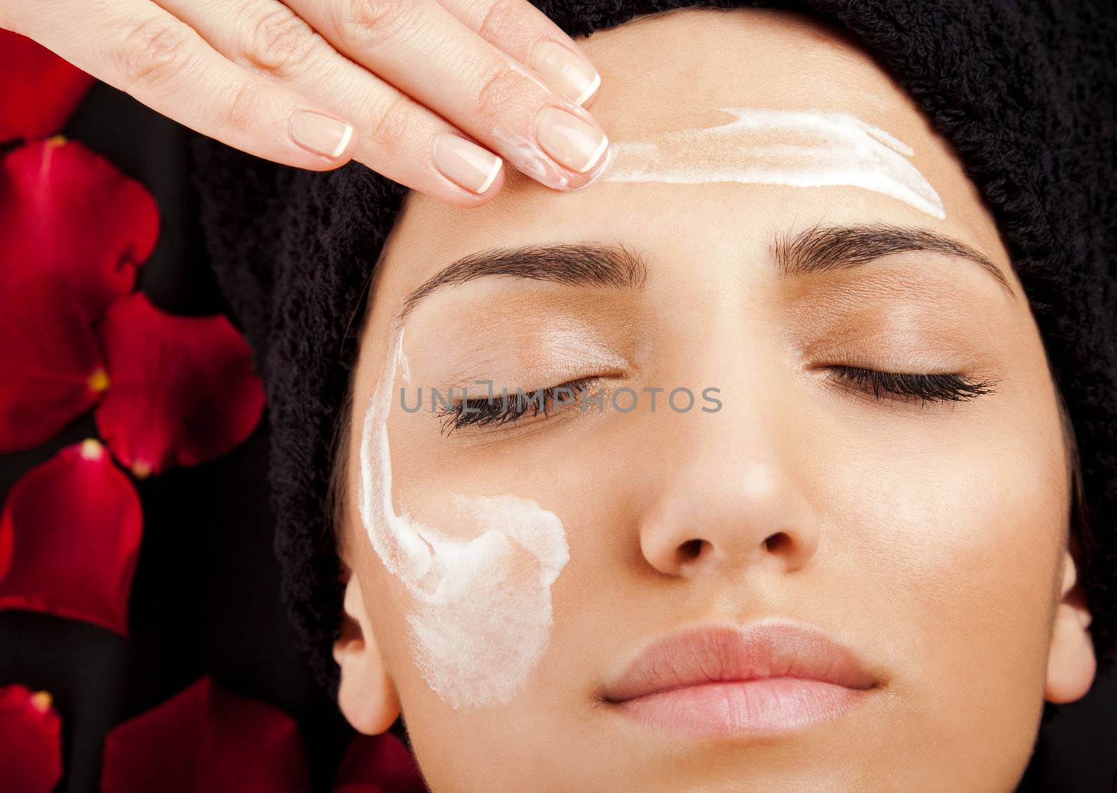 female hand applying moisturizing cream on a woman�s face