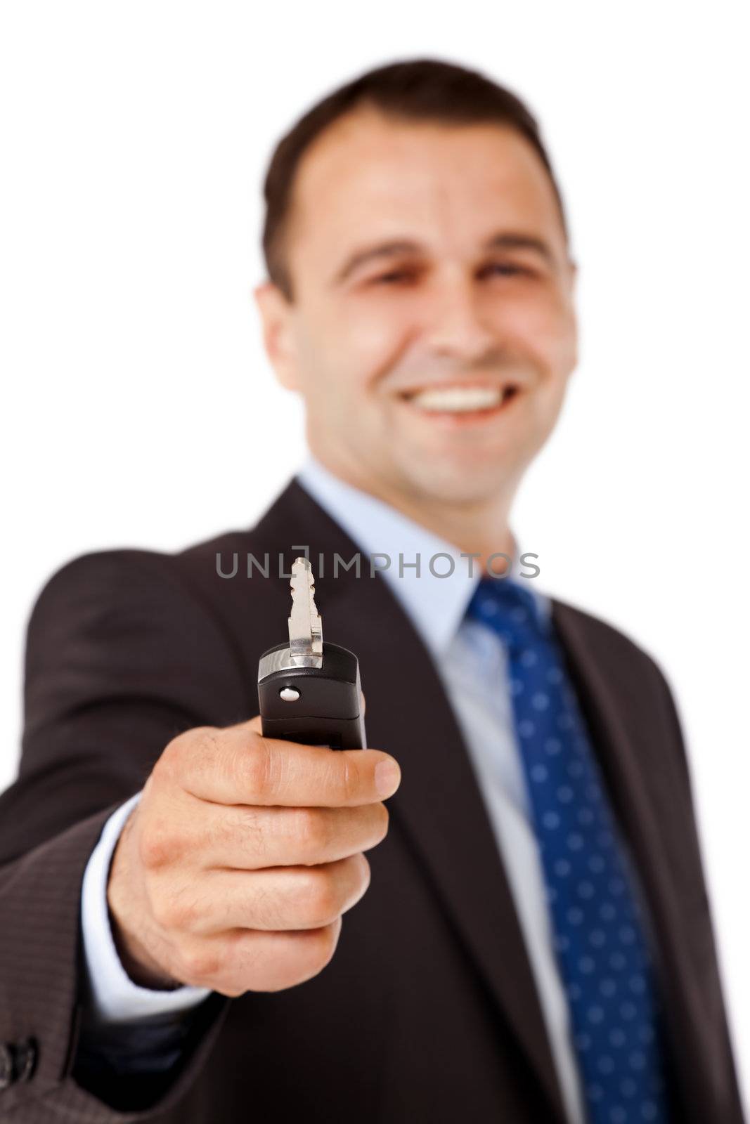 Portrait of happy businessman handing car key, focus on it