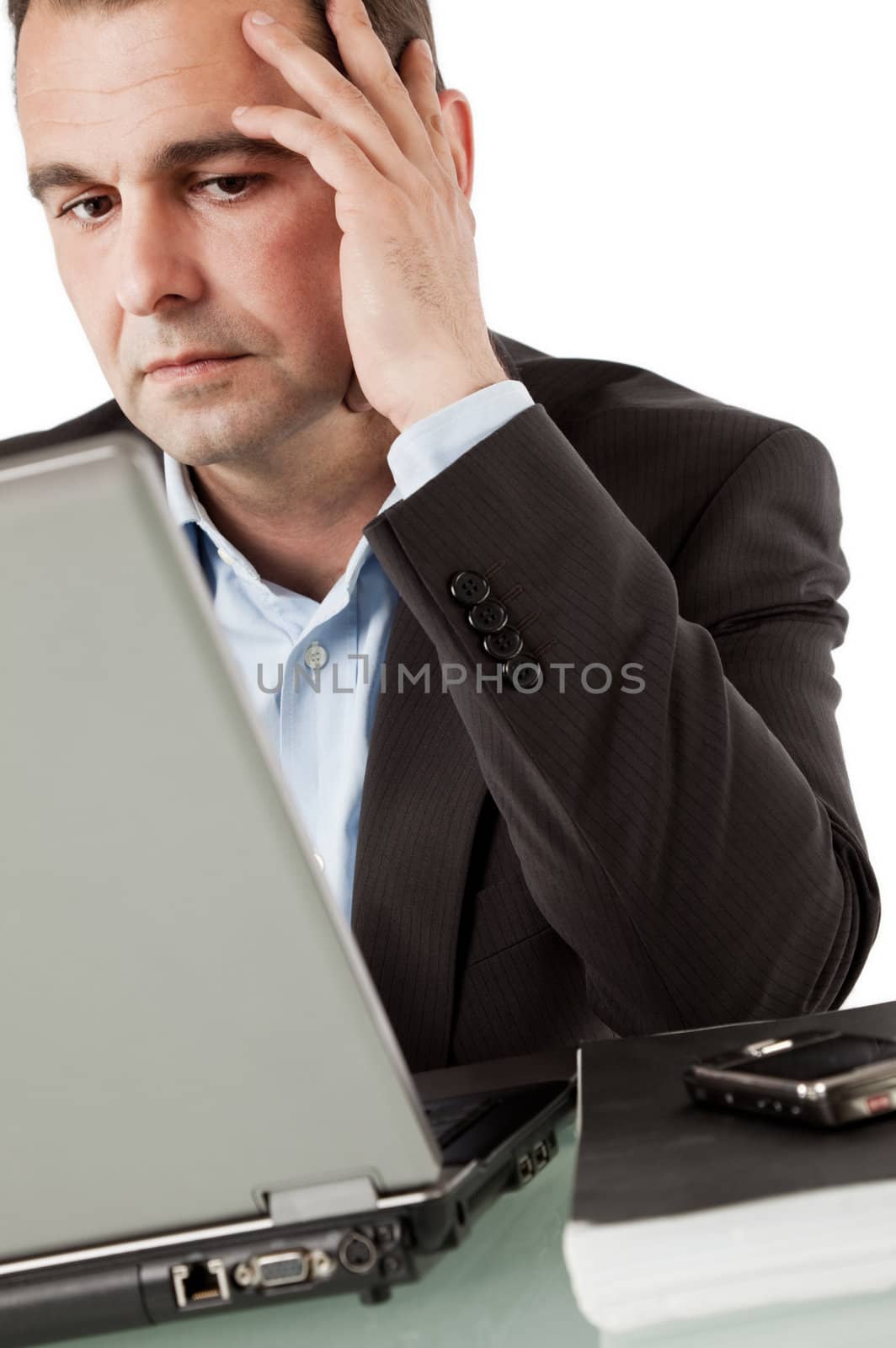 Businessman working on laptop, leaning hand on head thinking