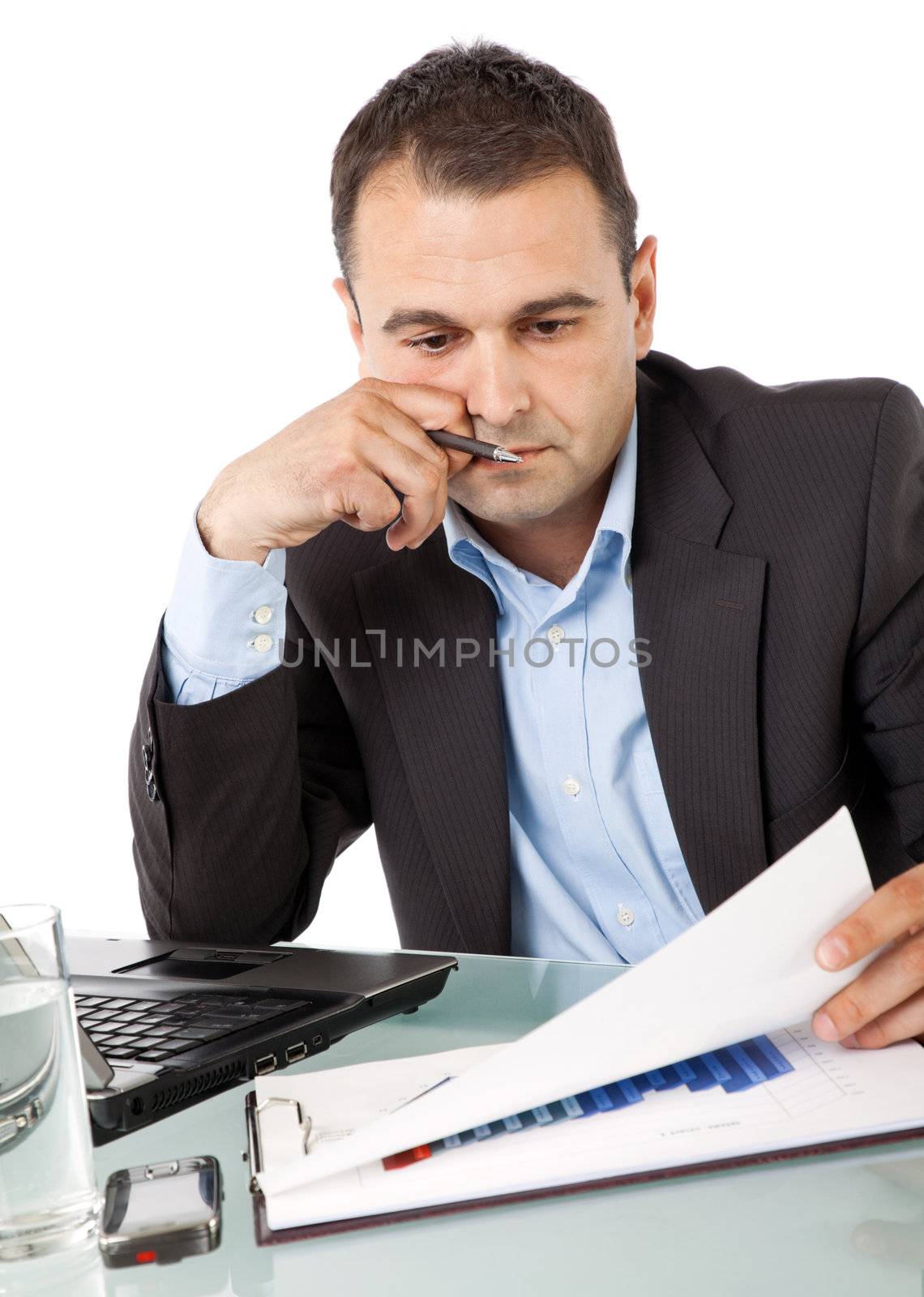 Portrait of businessman holding pen in hand, reading documents