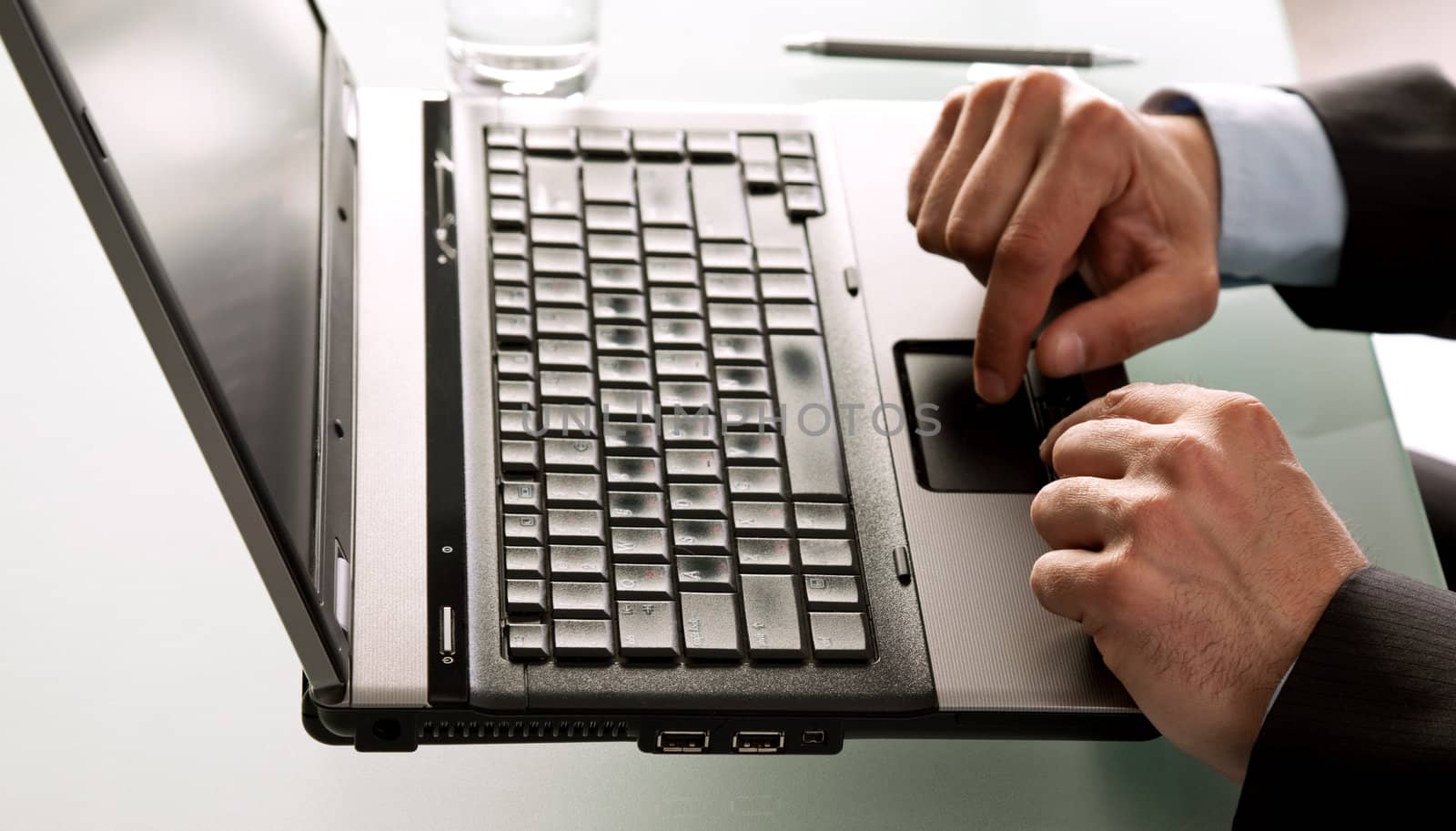 Close-up of male hands using laptop on desk