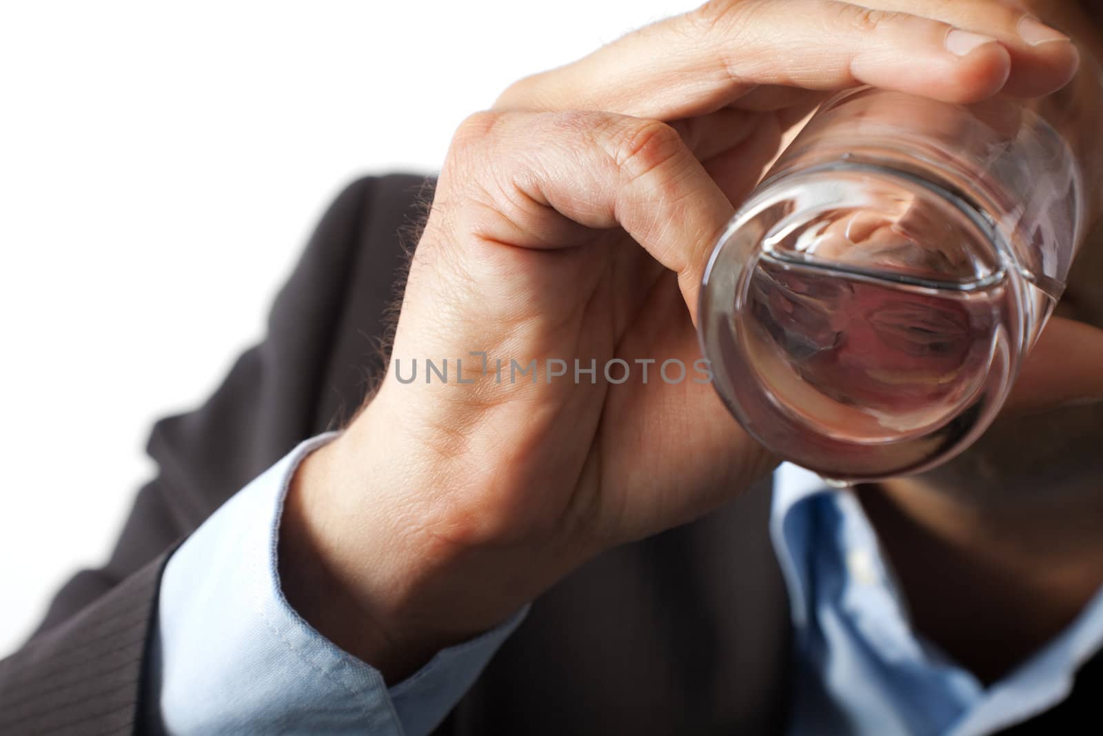 close-up of a thirsty man, no face, hand holding glass of water is seen