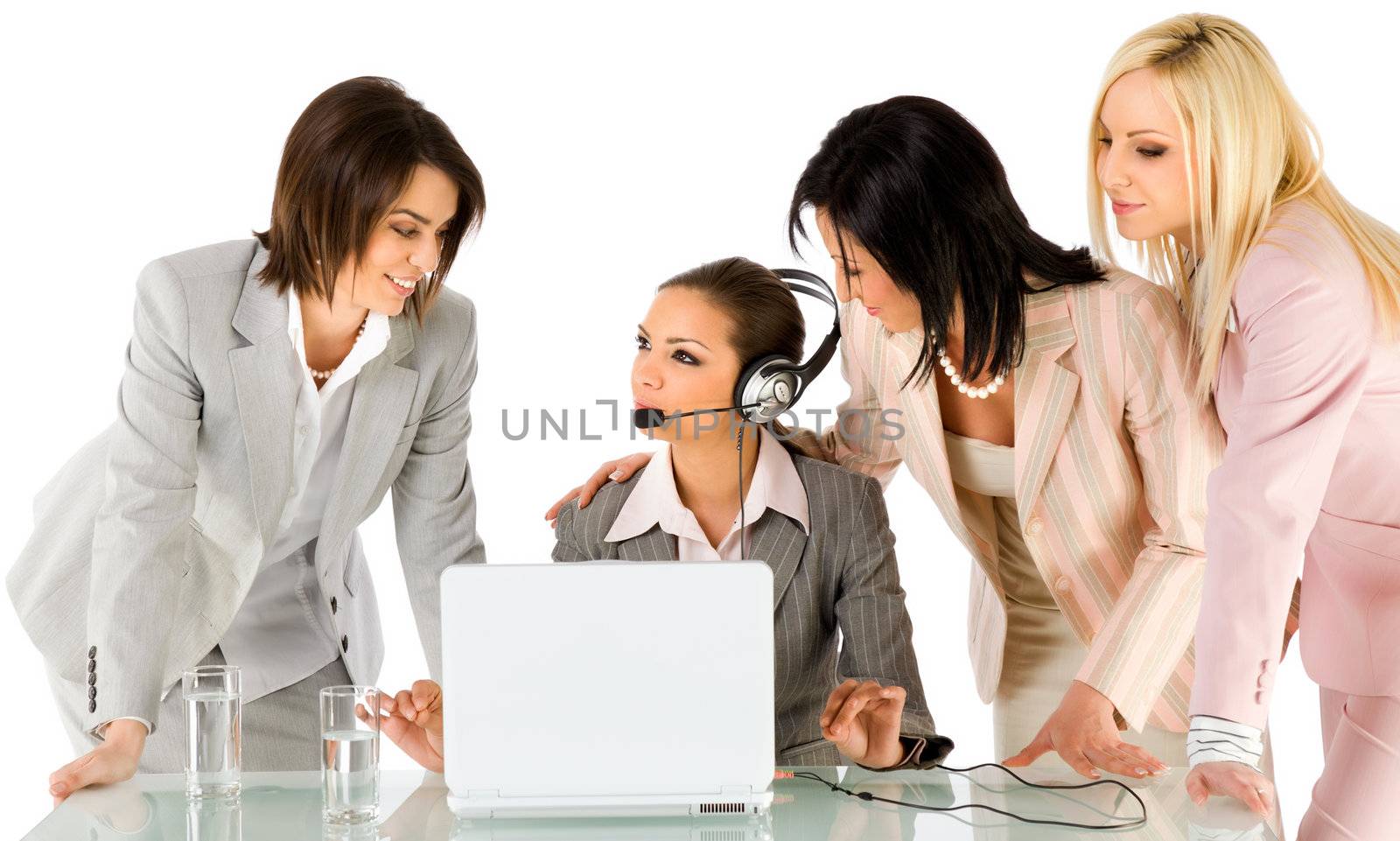 Successful team of four beautiful businesswomen talking behind laptop