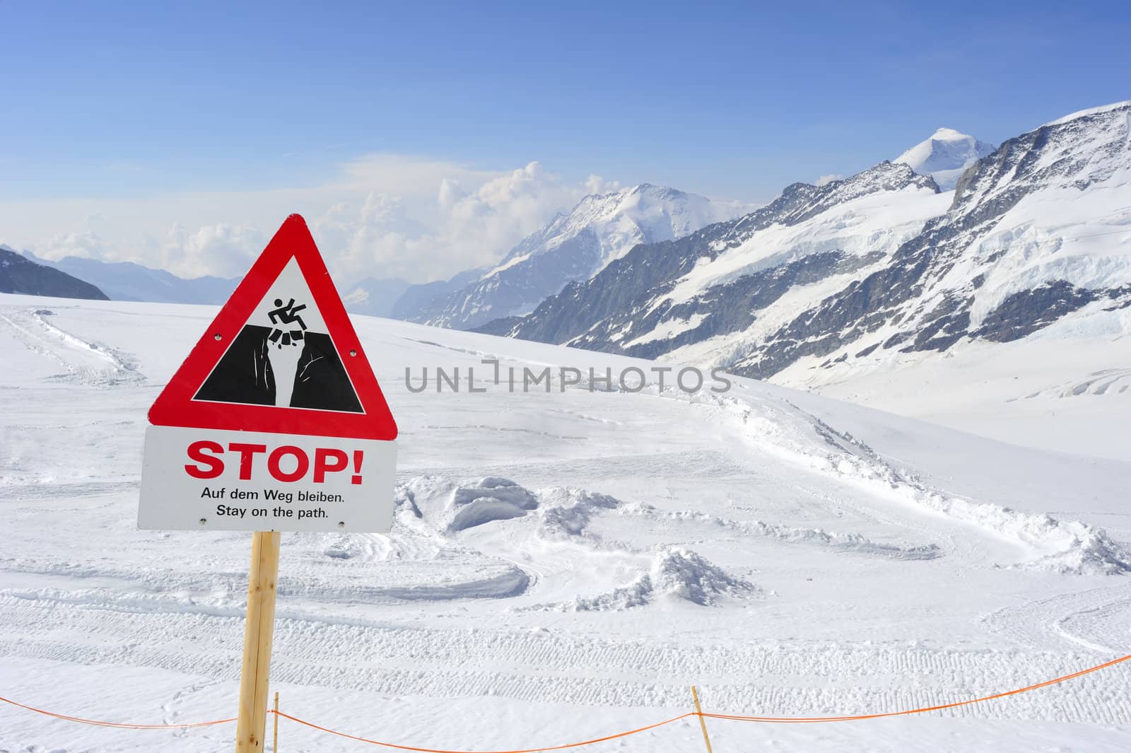 A sign warning walkers not to venture out on to the glacier beyond. Space for text in the sky.