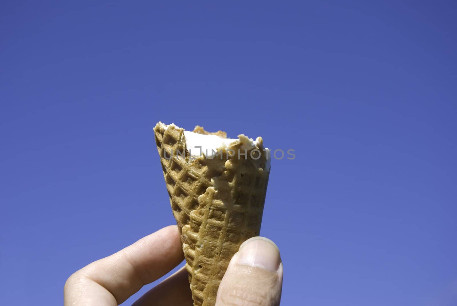 summer concept, ice--cream inn the hand on blue sky background