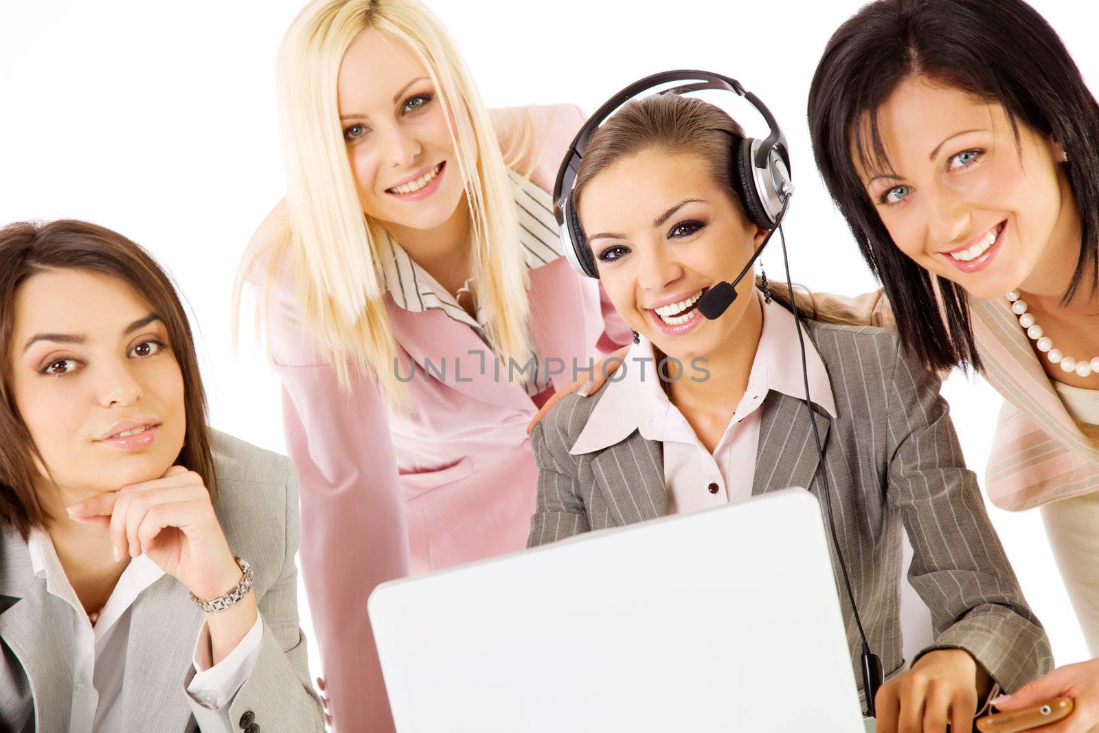successful team of four beautiful businesswomen smiling behind laptop, one with headset