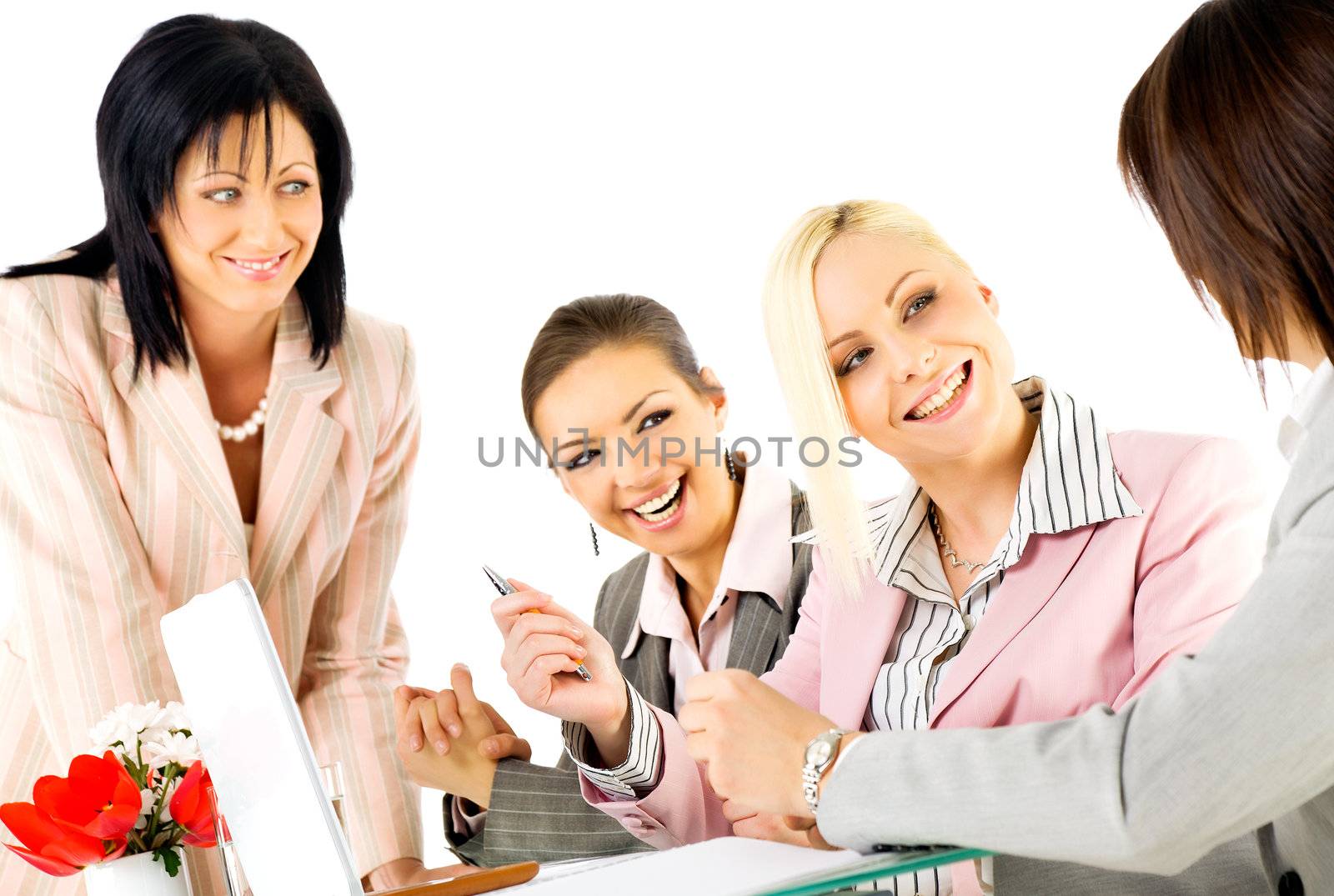 Team of four successful businesswomen working and smiling behind laptop
