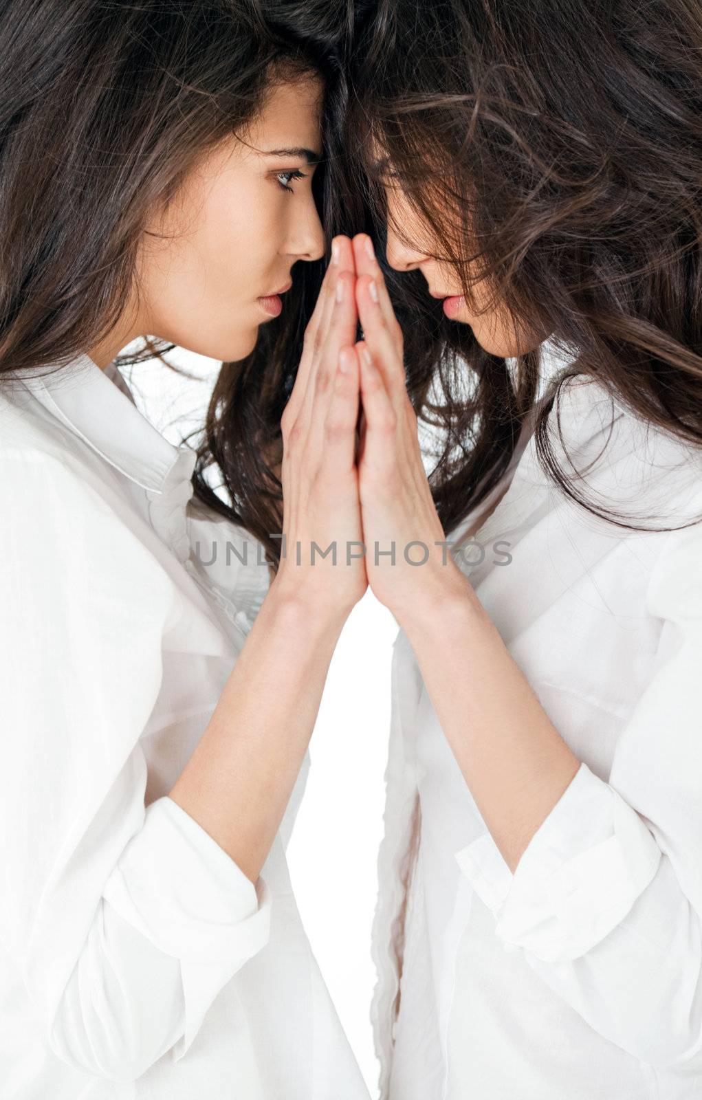 Close-up of beautiful twin girls mirror effect touching hands