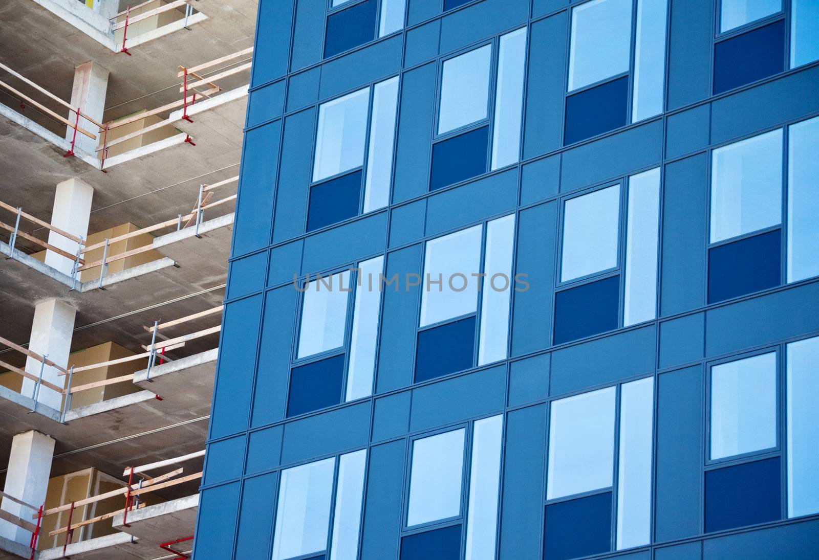 new glass facade and unfinished office building yet in construction