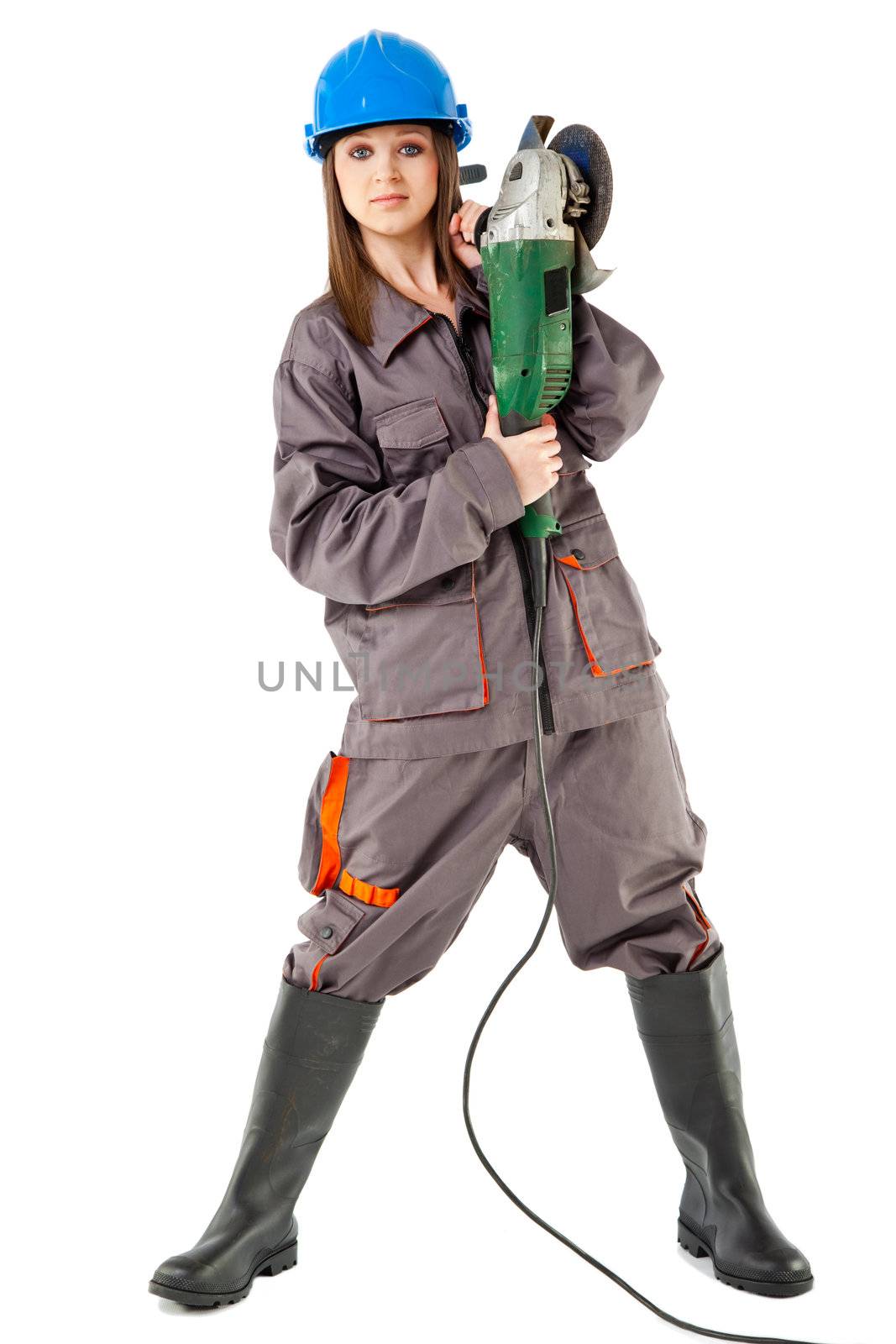 Beautiful young female with workwear and boots standing and holding grinder