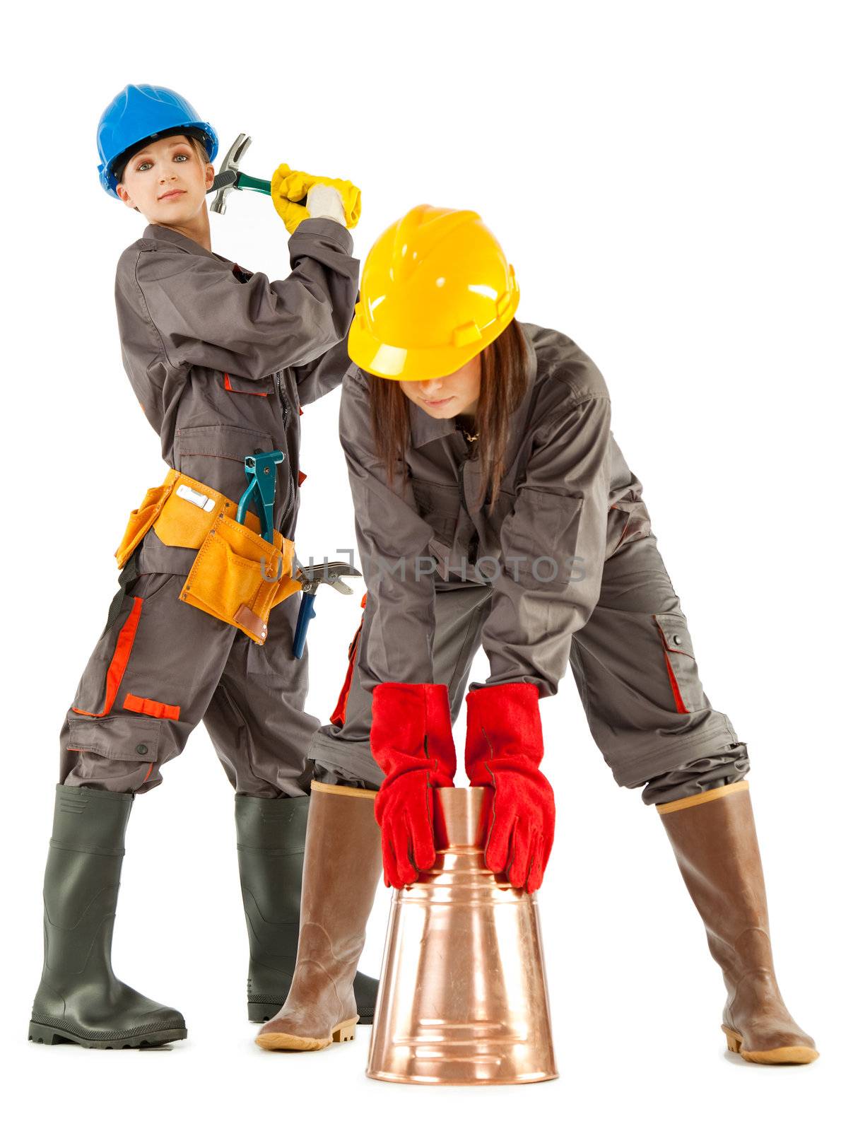 Two female construction workers posing with instruments, isolated