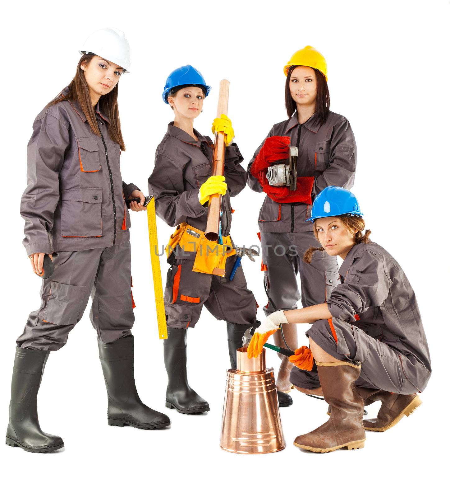Four female construction workers posing with instruments, isolated