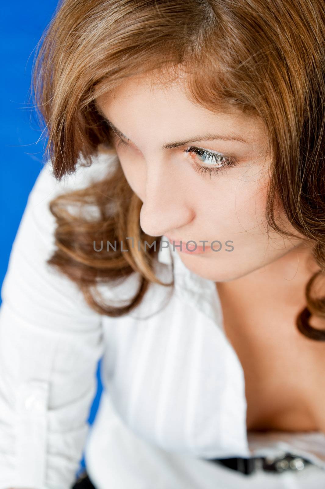 Portrait of young redhead woman with white shirt looking left