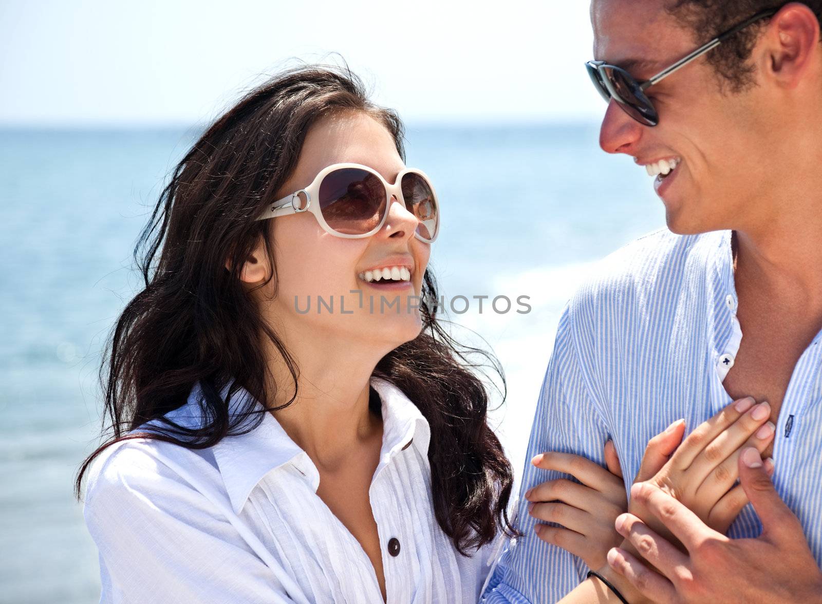 Couple holding hands beach by vilevi