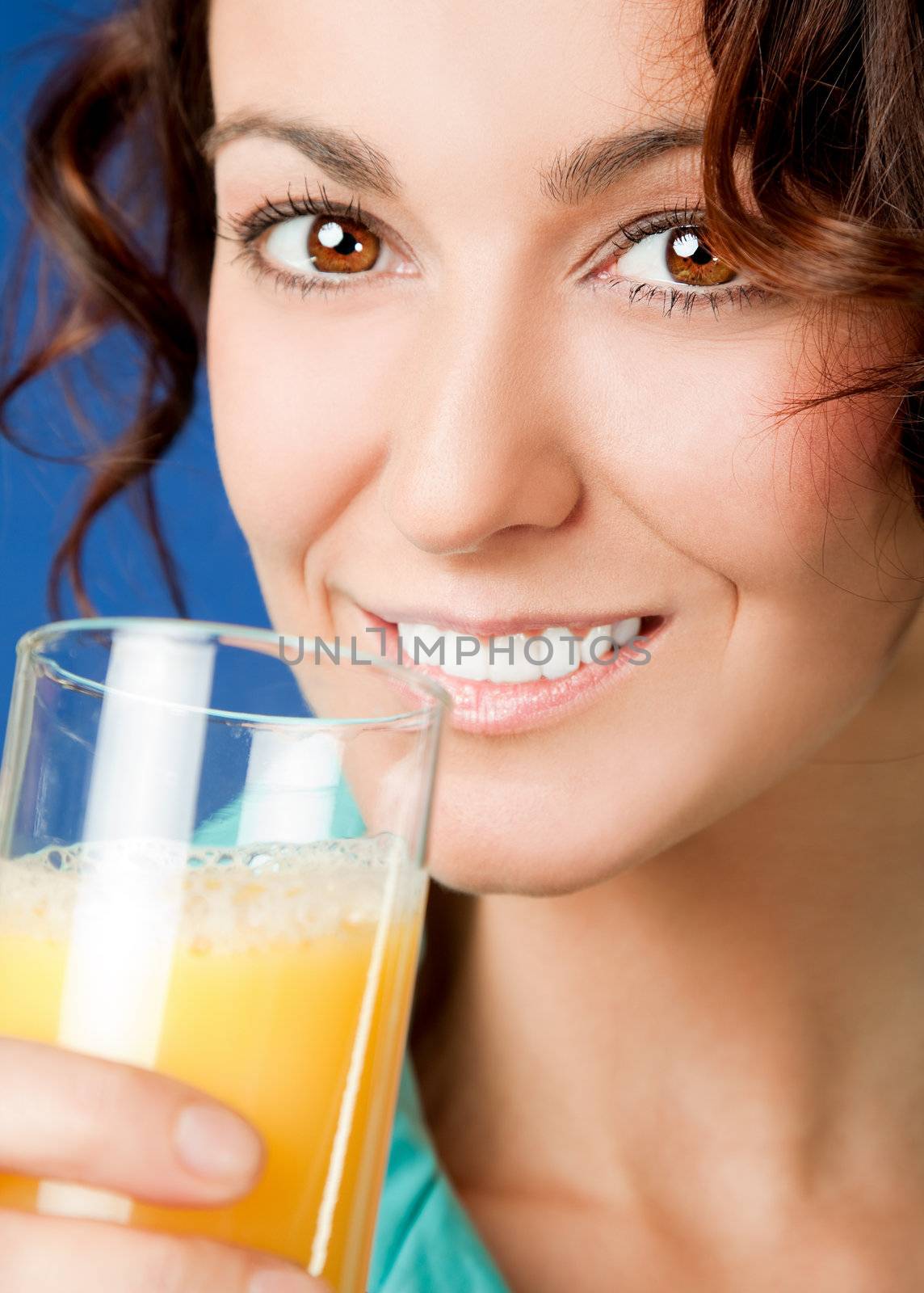 Close-up of young beautiful woman holding glass of orange juice