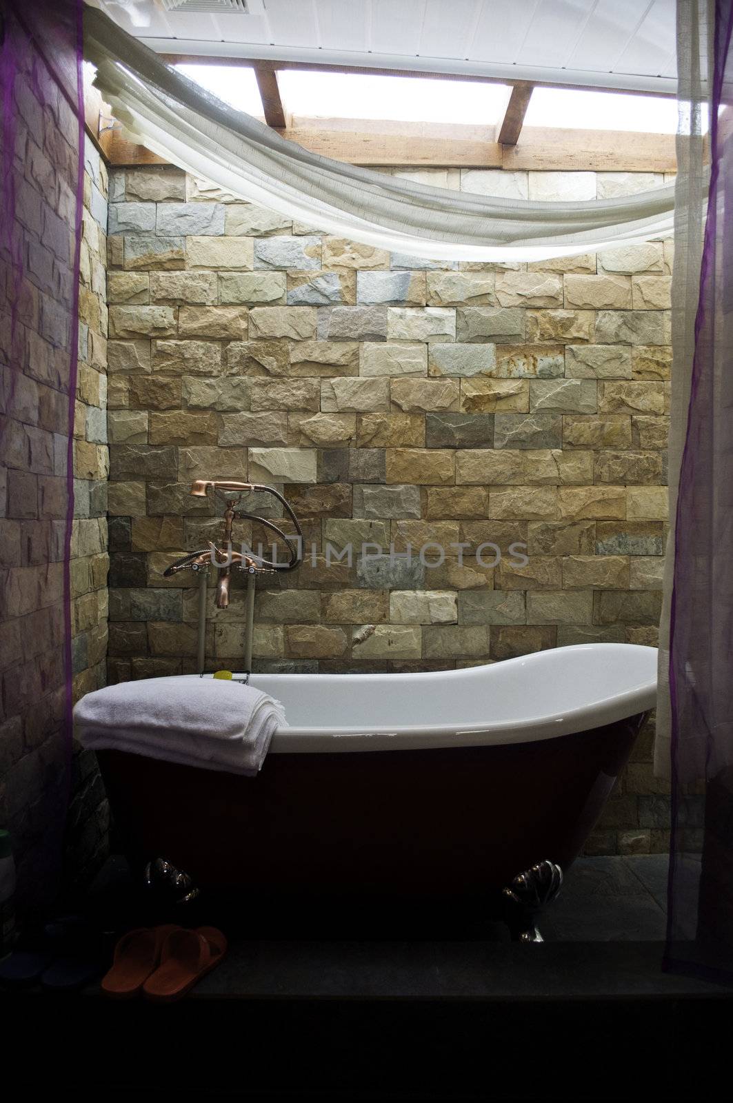 A decorative Bathtub with brown brick walls