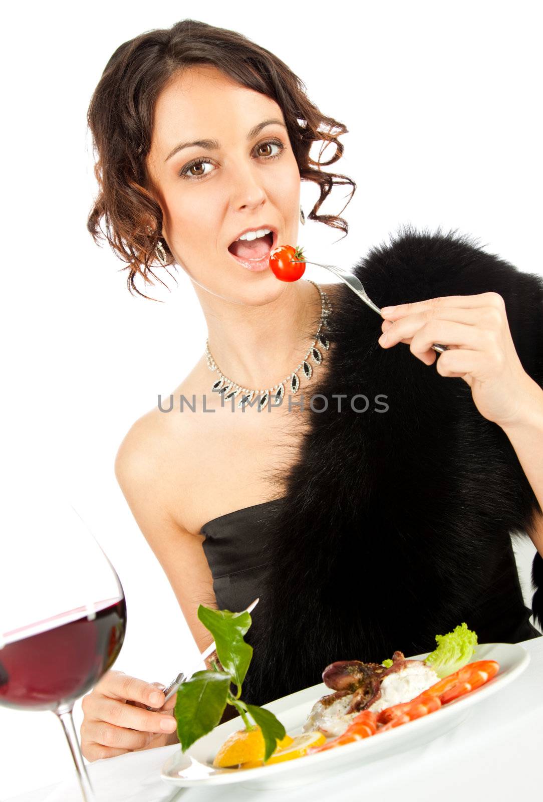 Beautiful elegant female sitting in restaurant eating salad