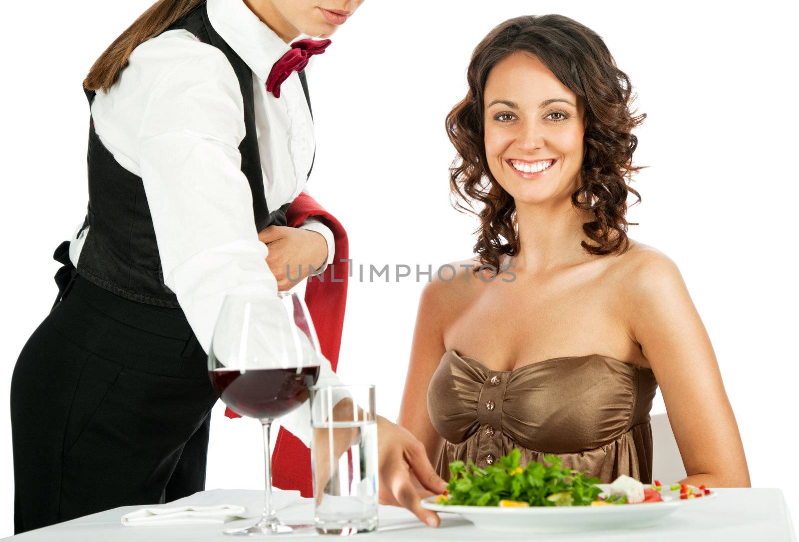 Beautiful female smiling and sitting in restaurant, being served salad by waitress
