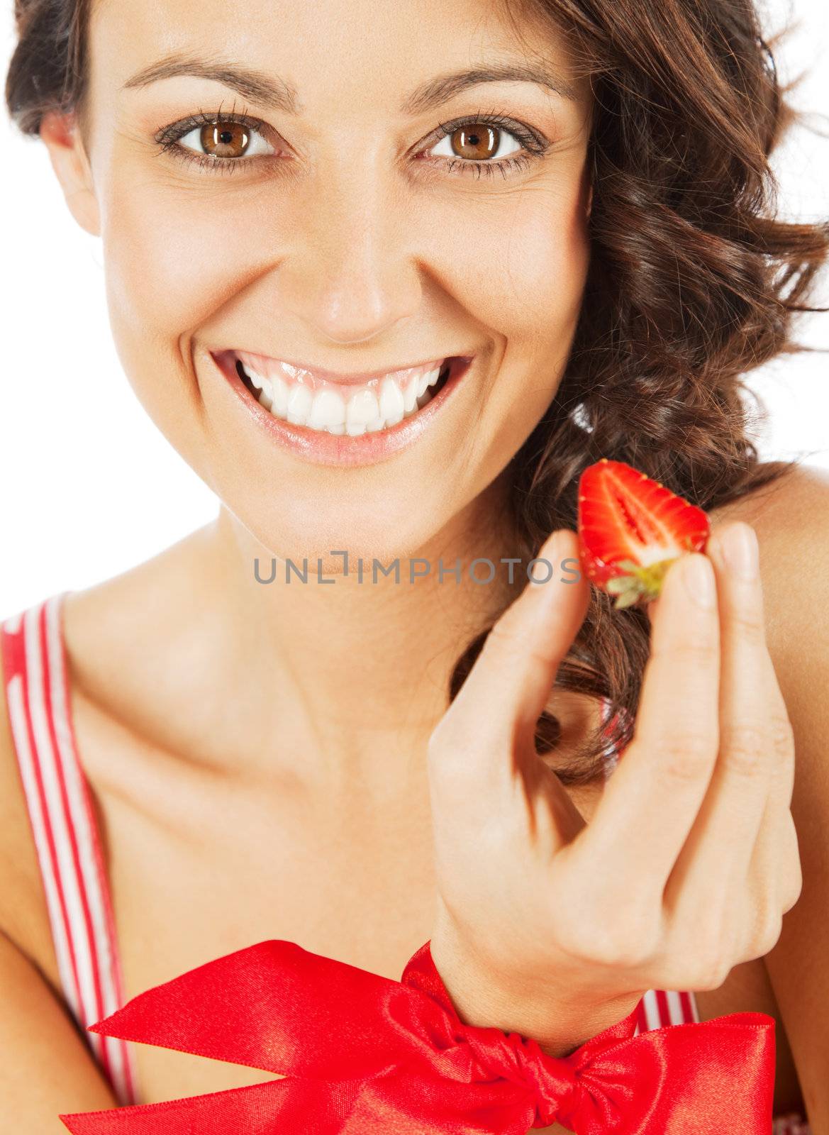 Portrait of beautiful happy woman with a cut strawberry in hand