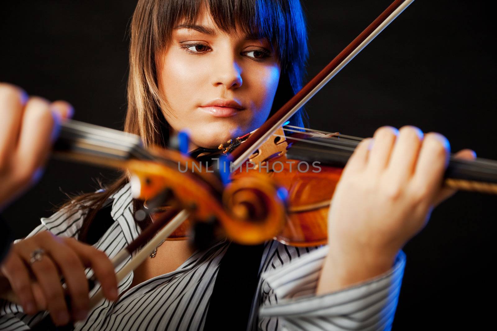 portrait of a beautiful young violinist playing violin