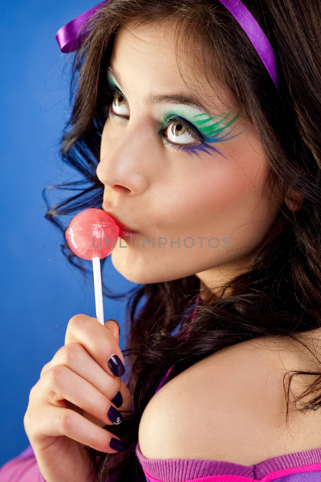 beautiful girl colourfull make-up licking lollipop looking up